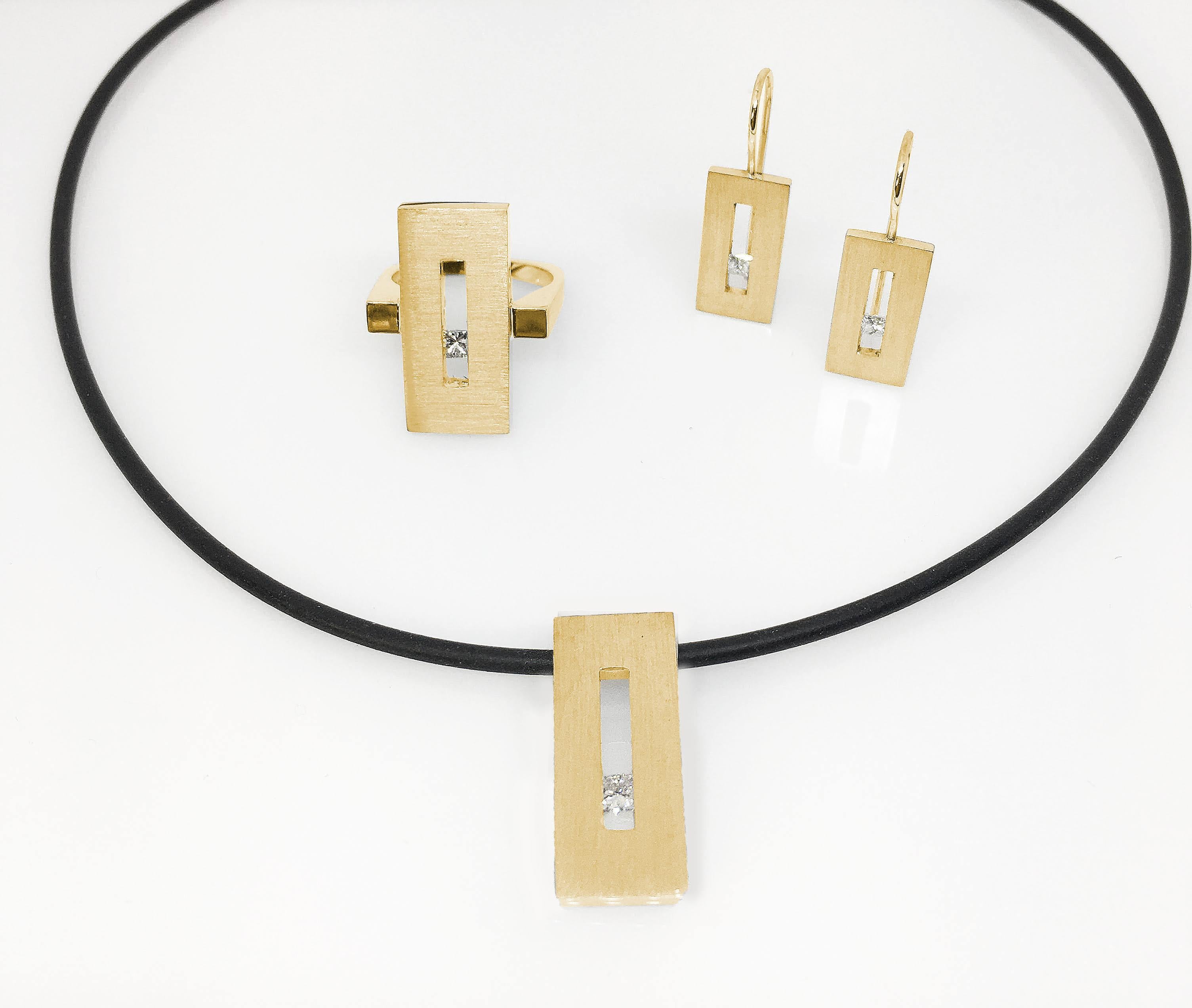 This Princess Diamond in Yellow Gold Suspended Rectangle Pendant on Rubber Cord is part of our Suspension Collection. Modern and architecturally inspired, this rectangle pendant is shown in yellow gold with a brushed finish and set off center with