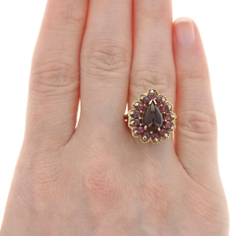 Size: 6 3/4
Sizing Fee: Down 2 sizes for $30 or up 2 sizes for $35

Metal Content: 14k Yellow Gold

Stone Information
Genuine  Rhodolite Garnet Solitaire
Carat: 1.80ct
Cut: Pear Cabochon
Color: Purplish Red

Genuine Rhodolite Garnet Accents
Carats: