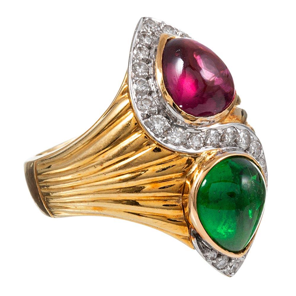 Opposing pear cabochons of pink and green tourmaline are accented with a serpentine stroke of white diamonds in this sophisticated and artful creation. Similar to Bulgari’s iconic designs, the piece combines a ribbed shank that resembles gathered