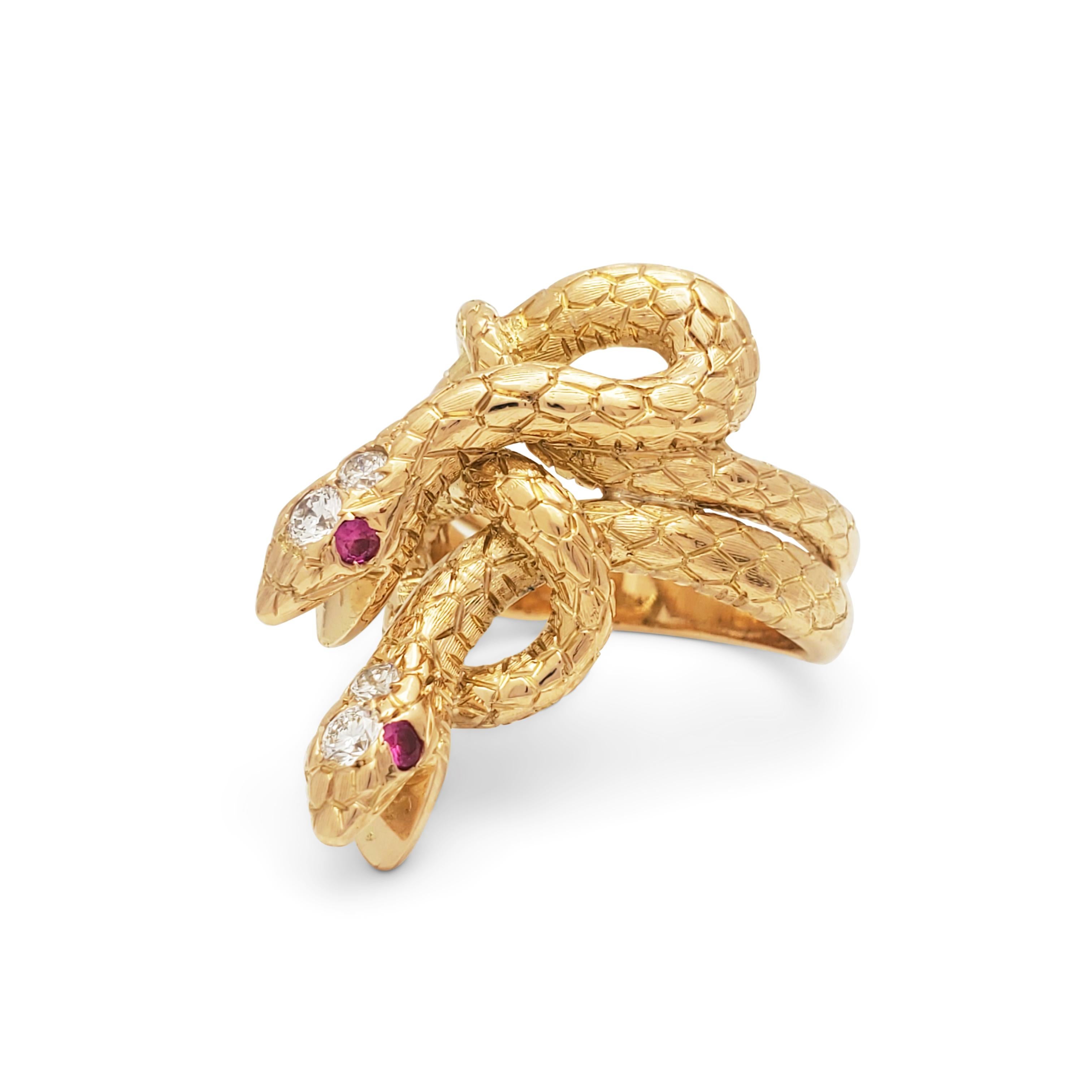 A striking ring crafted in 18 karat yellow gold depicting two intertwined snakes.  Each snake is set with mesmerizing ruby eyes and two diamonds at the top of the head for an estimated 0.20 carats total diamond weight.  The snake motif measures 1.07