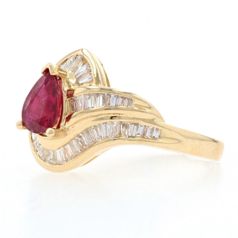 Surprise your July birthday girl with this gorgeous treasure! Crafted in 18k yellow gold, this luxurious bypass ring showcases a majestic ruby that is elegantly surrounded by a heavenly array of icy white diamonds to form a contemporary halo around