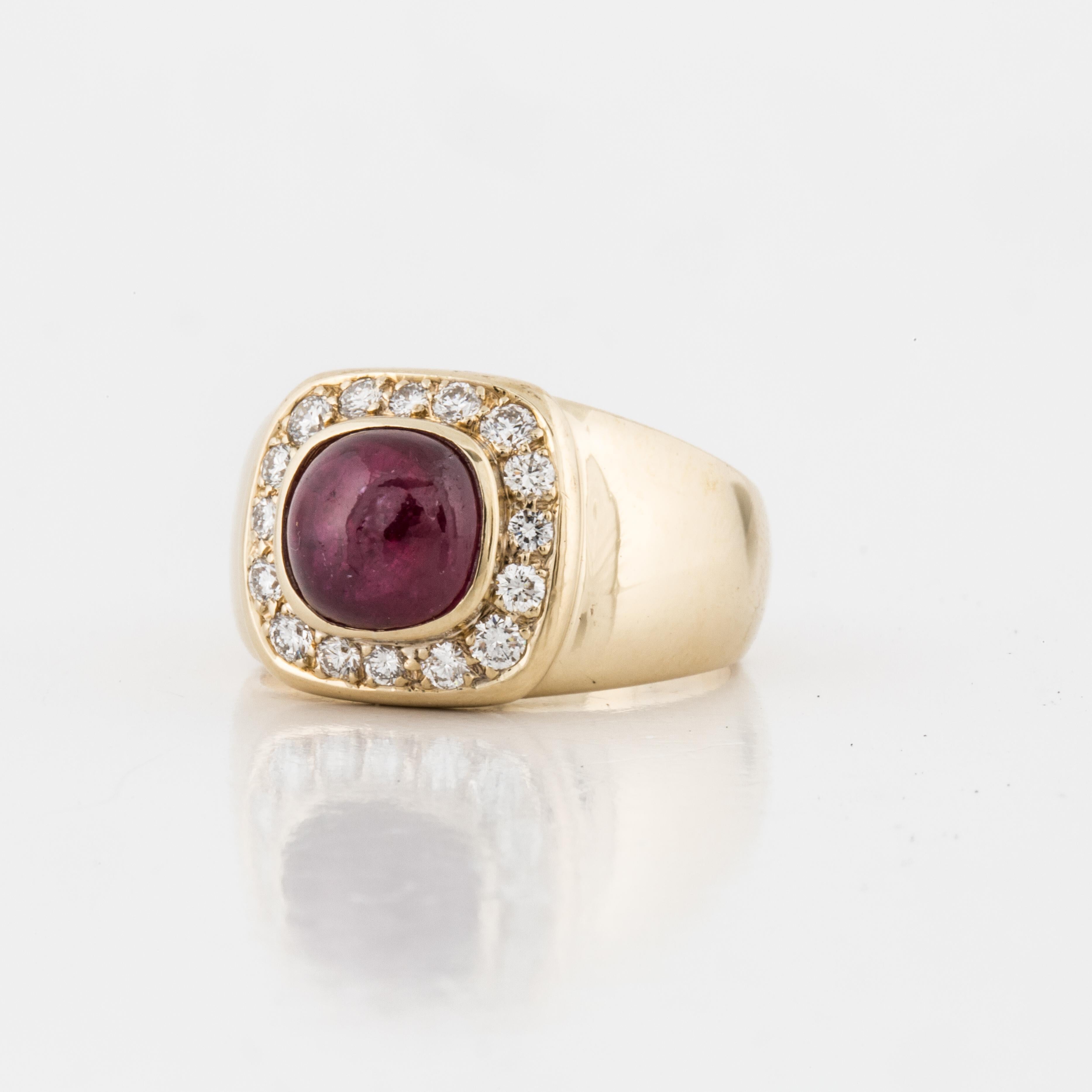 14K yellow gold ring featuring a cabochon ruby surrounded by diamonds.  There are sixteen round diamonds totaling 0.45 carats; G-H color and VS1-2 clarity.  The ring is currently a size 5 1/2.  The presentation area measures 1/2 inch by 7/16 of an