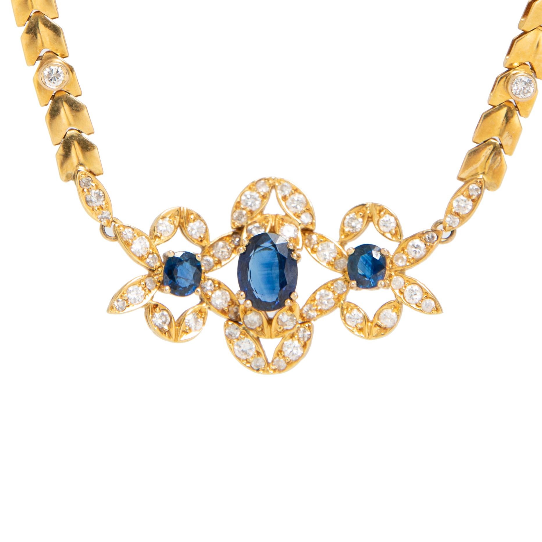 A Yellow Gold, Sapphire and Diamond necklace containing one oval shape mixed cut sapphire measuring approximately 9.00 x 6.95 x 3.20 mm, two oval shape mixed cut sapphires and 66 round brilliant cut diamonds weighing approximately 1.75 carats total