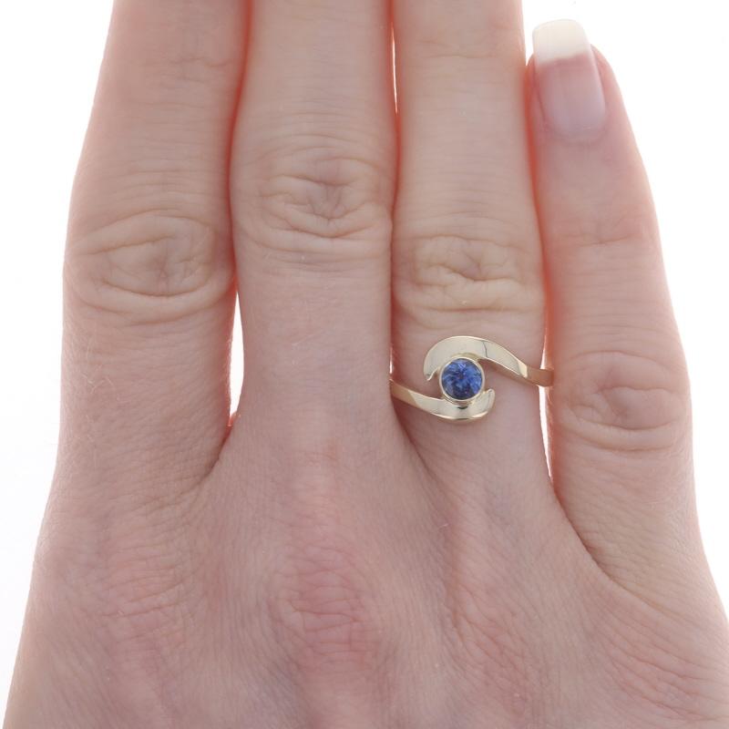 Size: 6
Sizing Fee: Up 2 sizes for $35 or Down 2 sizes for $30

Metal Content: 14k Yellow Gold

Stone Information
Natural Sapphire
Treatment: Heating
Carat(s): .42ct
Cut: Round
Color: Blue

Total Carats: .42ct

Style: Bypass