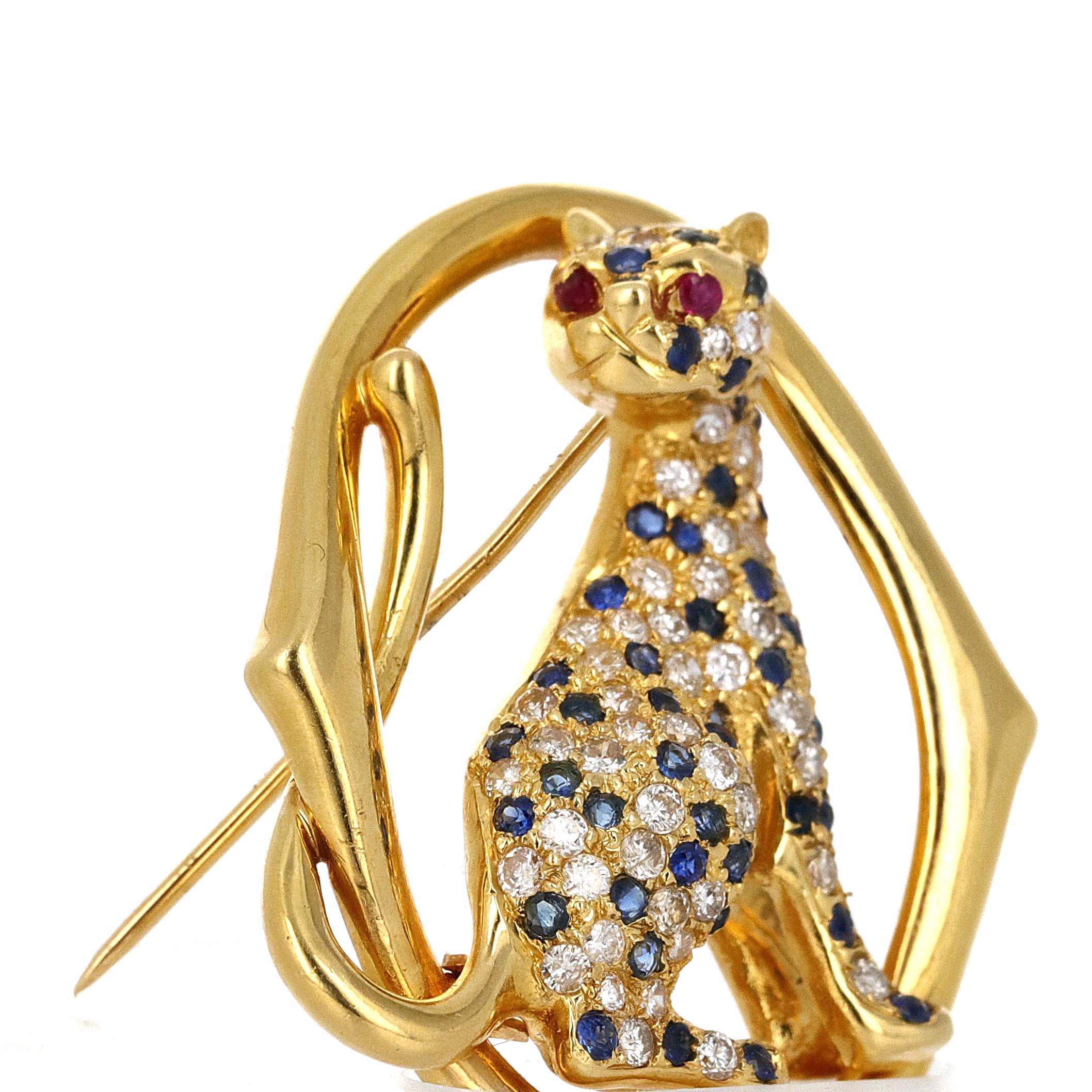 18 karat yellow gold Panther brooch. The body is adorned with round white diamonds and round blue sapphires. The panthers eyes are made with rubies. This is a very clean and sleek design. This can be worn by both male and female. It's a great pin to