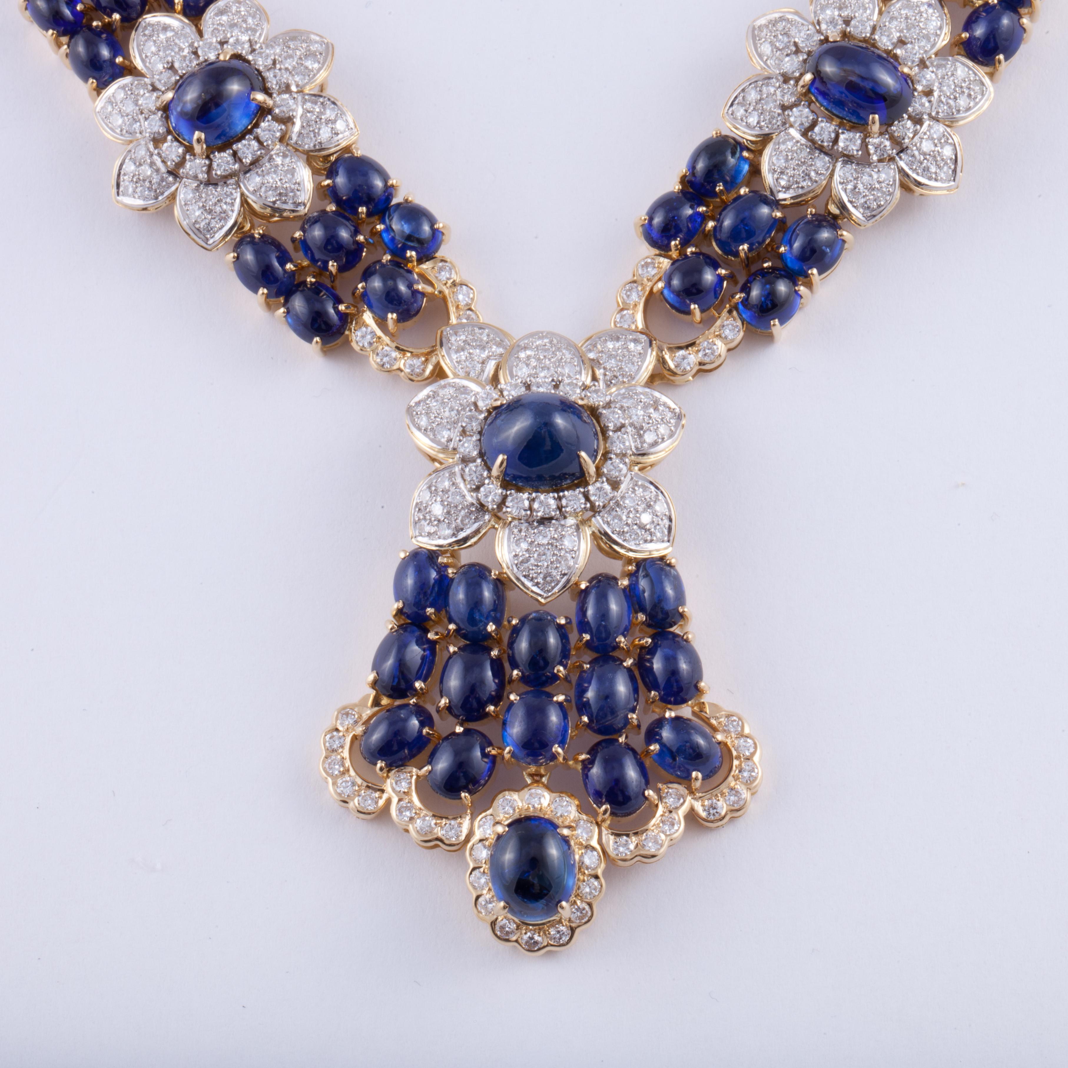 18K yellow gold necklace featuring cabochon blue sapphires and diamonds.  There are 91.37 carats of sapphires and 7.97 carats of round diamonds.  The drop includes a flower with cascading sapphires and diamonds.  It measures 2 1/8 inches long and 1