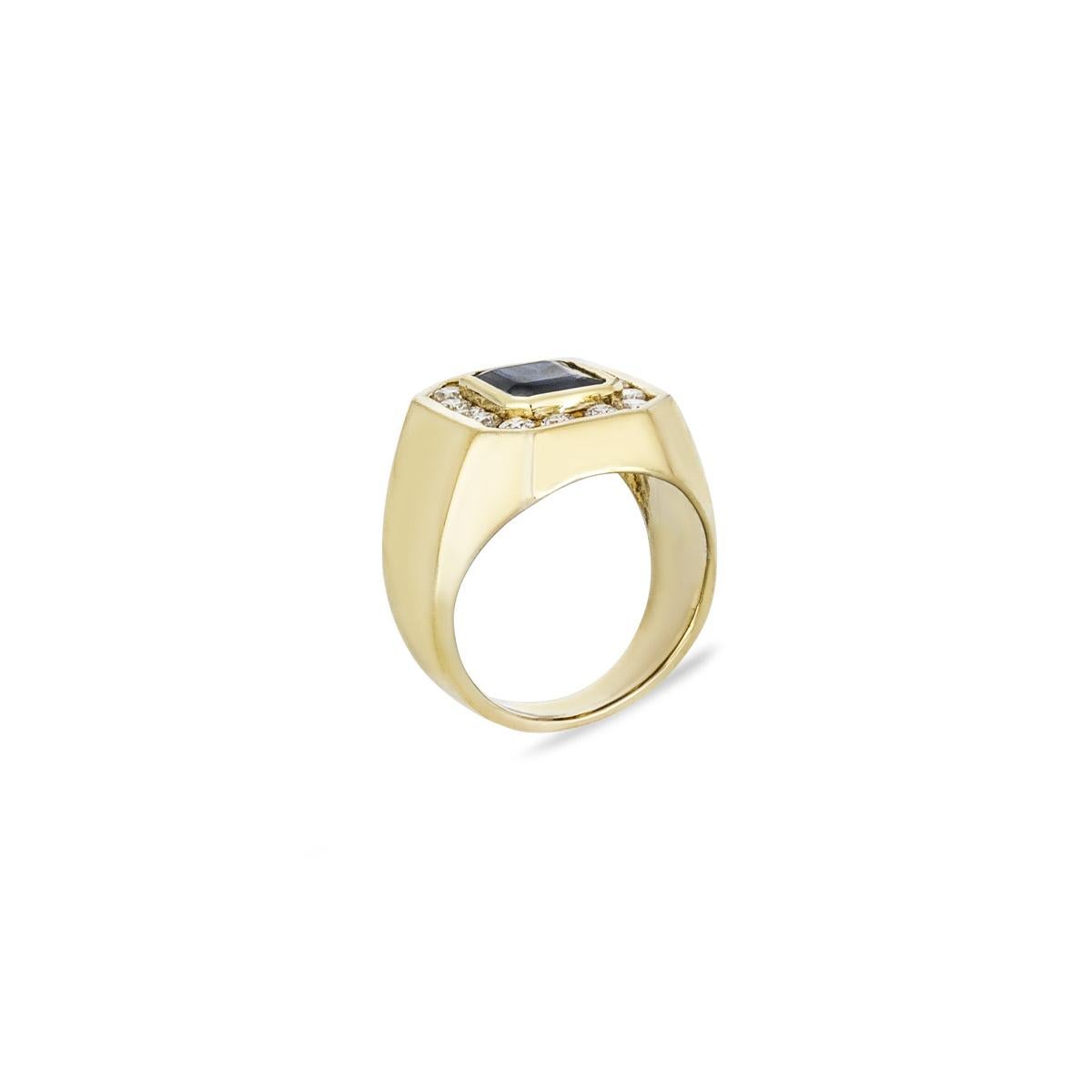 Ein traditioneller Ring aus 18 Karat Gelbgold mit Saphiren und Diamanten. In der Mitte des Rings befindet sich ein Saphir im Smaragdschliff in einer Fassung mit einem Gewicht von ca. 1,25ct und einem dunkelblauen Farbton. Ergänzt wird der Saphir
