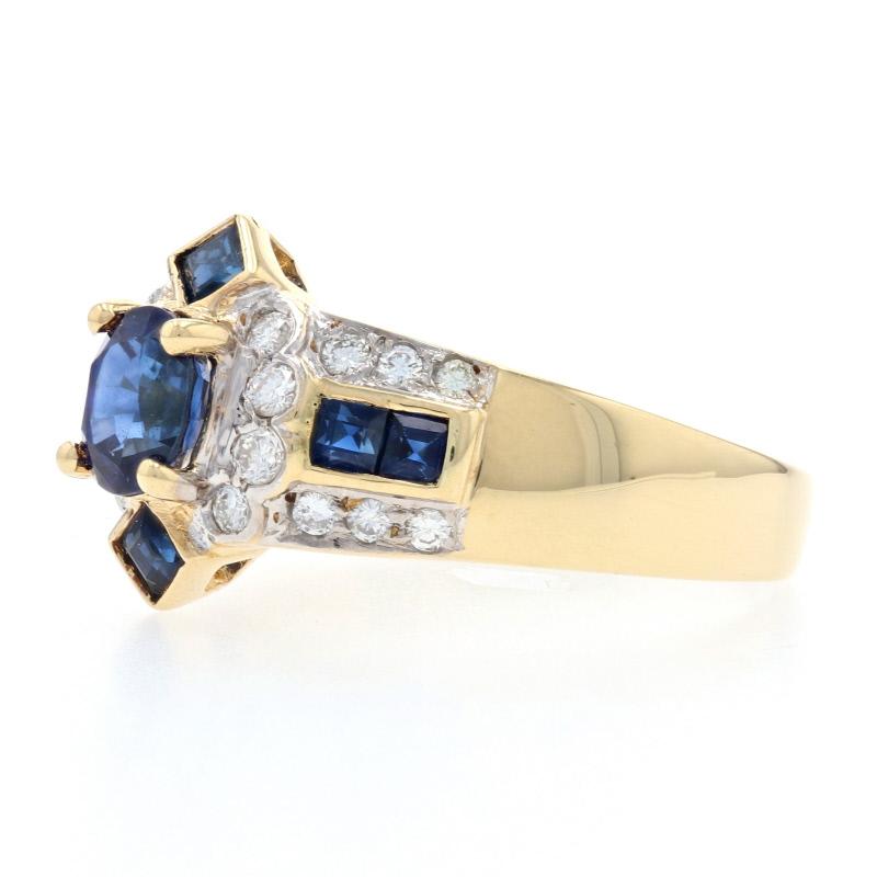 Crown your evening attire with a touch of regal brilliance! Composed of 18k yellow and white gold, this ring features a sumptuous blue sapphire solitaire framed by a sparkling collection of blue sapphires and white diamonds which create a luxurious