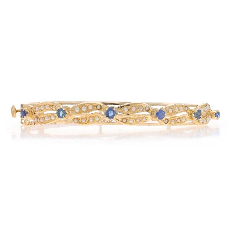 Era: Vintage

Metal Content: 14k Yellow Gold

Stone Information

Natural Sapphires
Treatment: Heating
Carat(s): 1.06ctw
Cut: Round
Color: Blue

Cultured Seed Pearls
Color: Cream

Total Carats: 1.06ctw

Style: Bangle
Fastening Type: Tab Box Clasp