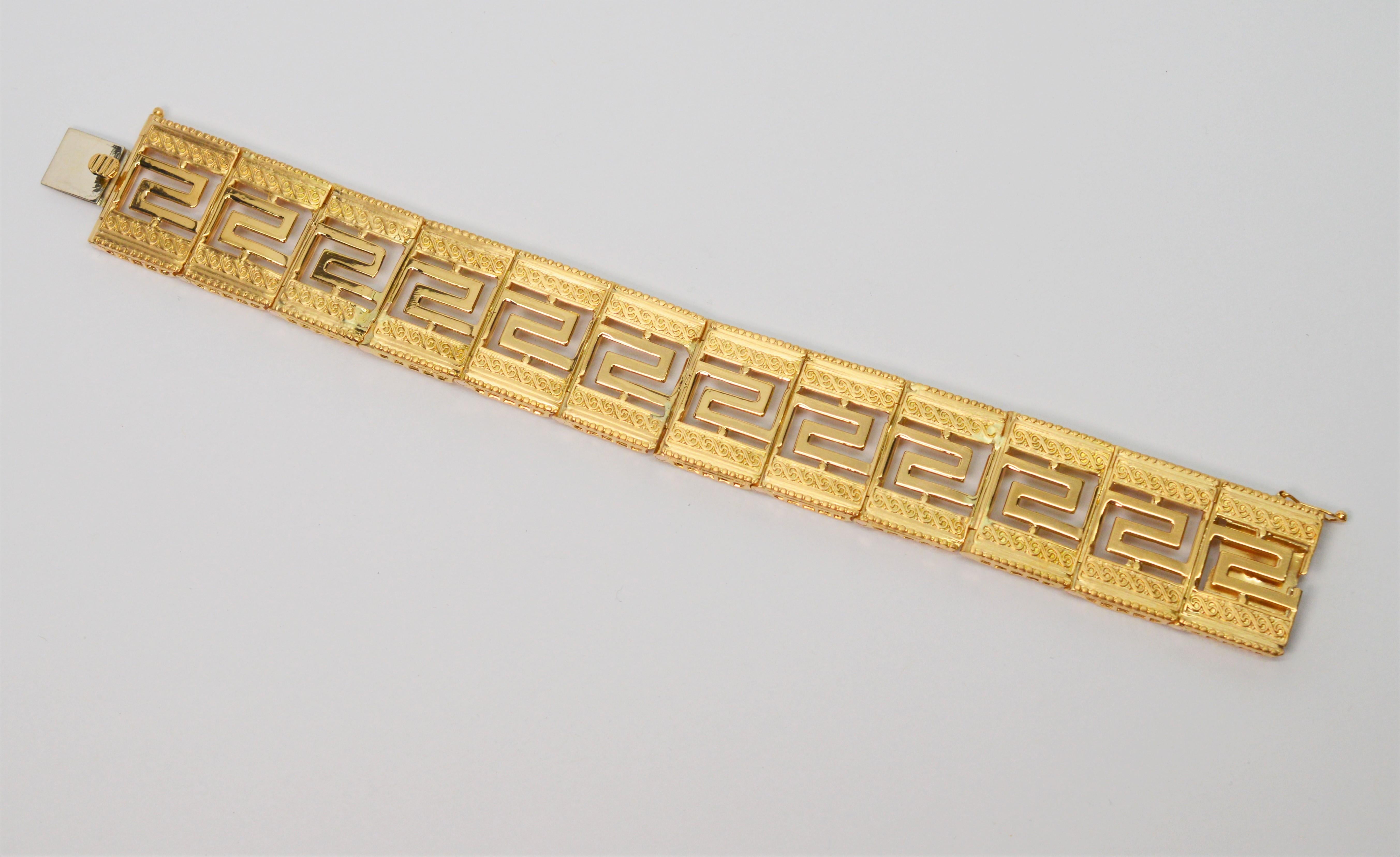 This stunning two-toned eighteen karat (18K) yellow gold geometric link bracelet with satin and bright finish details shows beautifully on the wrist. Circa 1950's, the substantial piece is crafted with rectangular tile-links enhanced with scroll