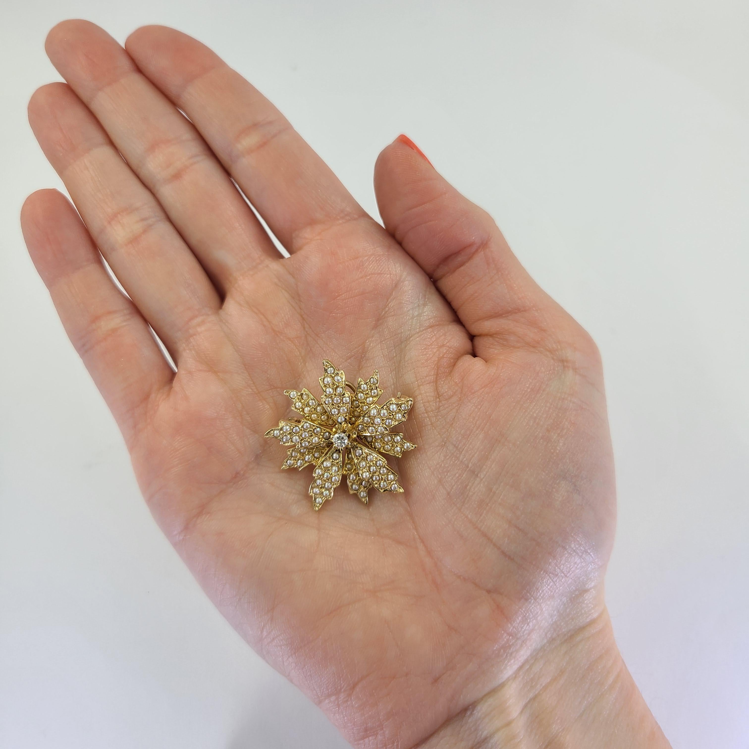 14 Karat Yellow Gold Flower Pin Featuring A 0.10 Carat Round Brilliant Cut Diamond Of SI Clarity & H Color & 155 Seed Pearls. 1 Inch Diameter. Finished Weight Is 9.1 Grams. Bale Folds Out To Convert To Slide Pendant.