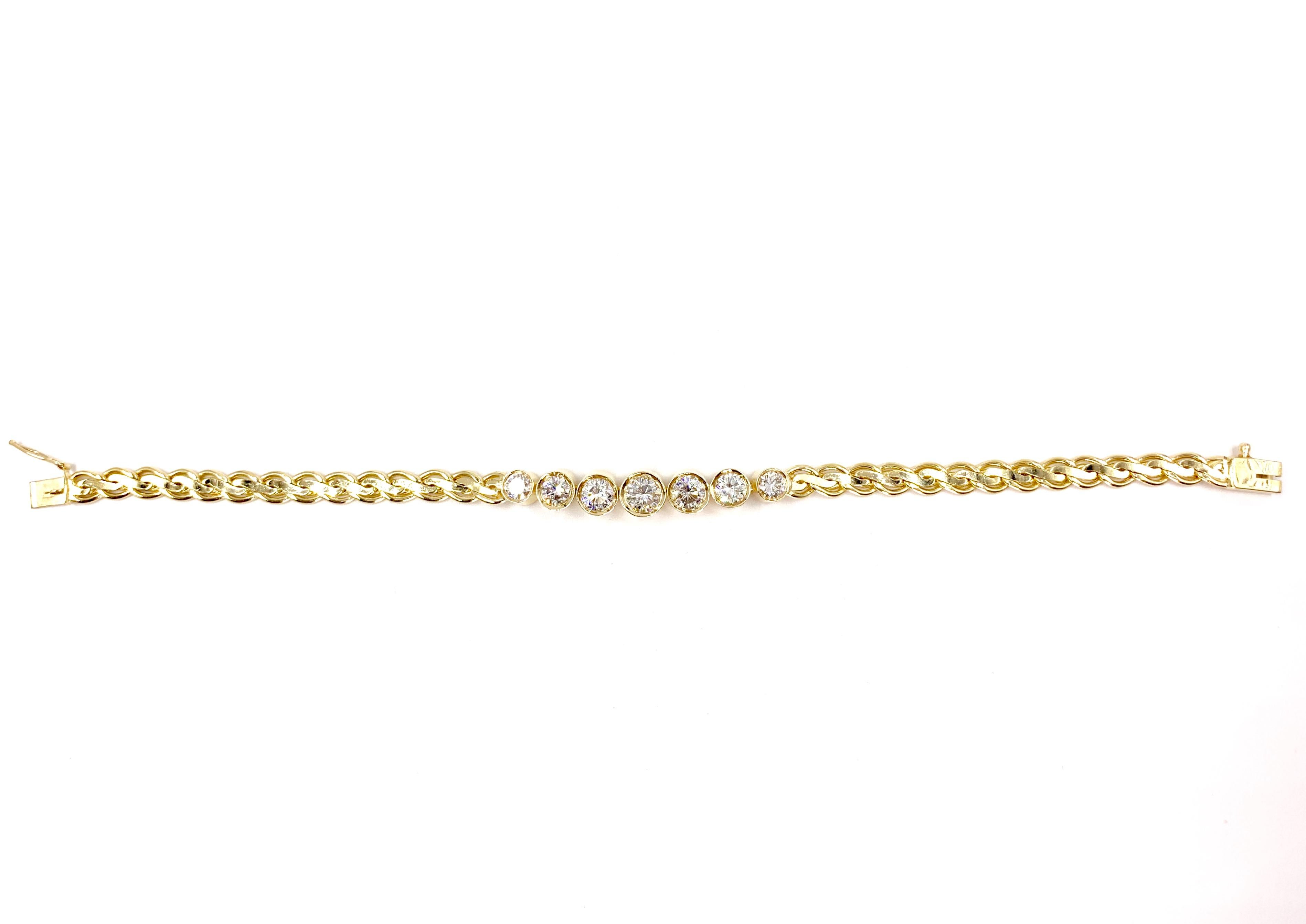 A classic and wearable bracelet featuring seven sizable round brilliant bezel set diamonds in the center of a 14 karat yellow gold polished flat fancy link chain. Diamonds have an approximate total weight of 3 carats with the center largest diamond