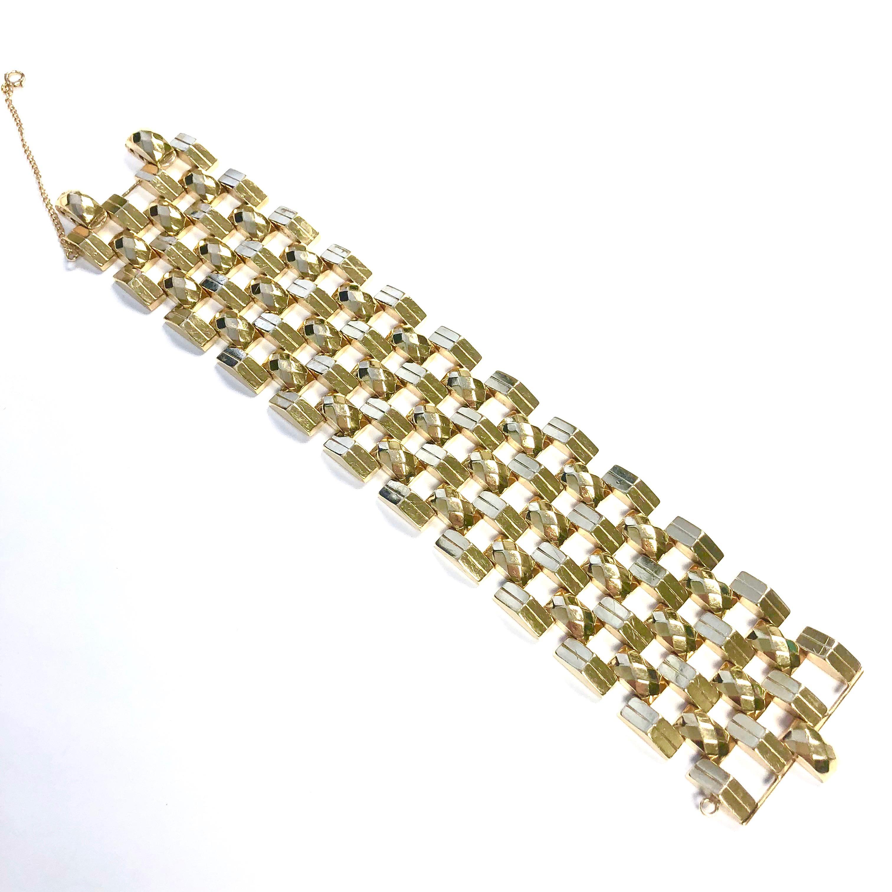 Crafted in 14K yellow gold, the bracelet is composed of four rows of cascading triangular shaped links alternating with three rows of faceted cushion shaped links. 
Measurements: 
Length: 7.5 inches
Width: 1.5 inches
Weight: 64.9 grams