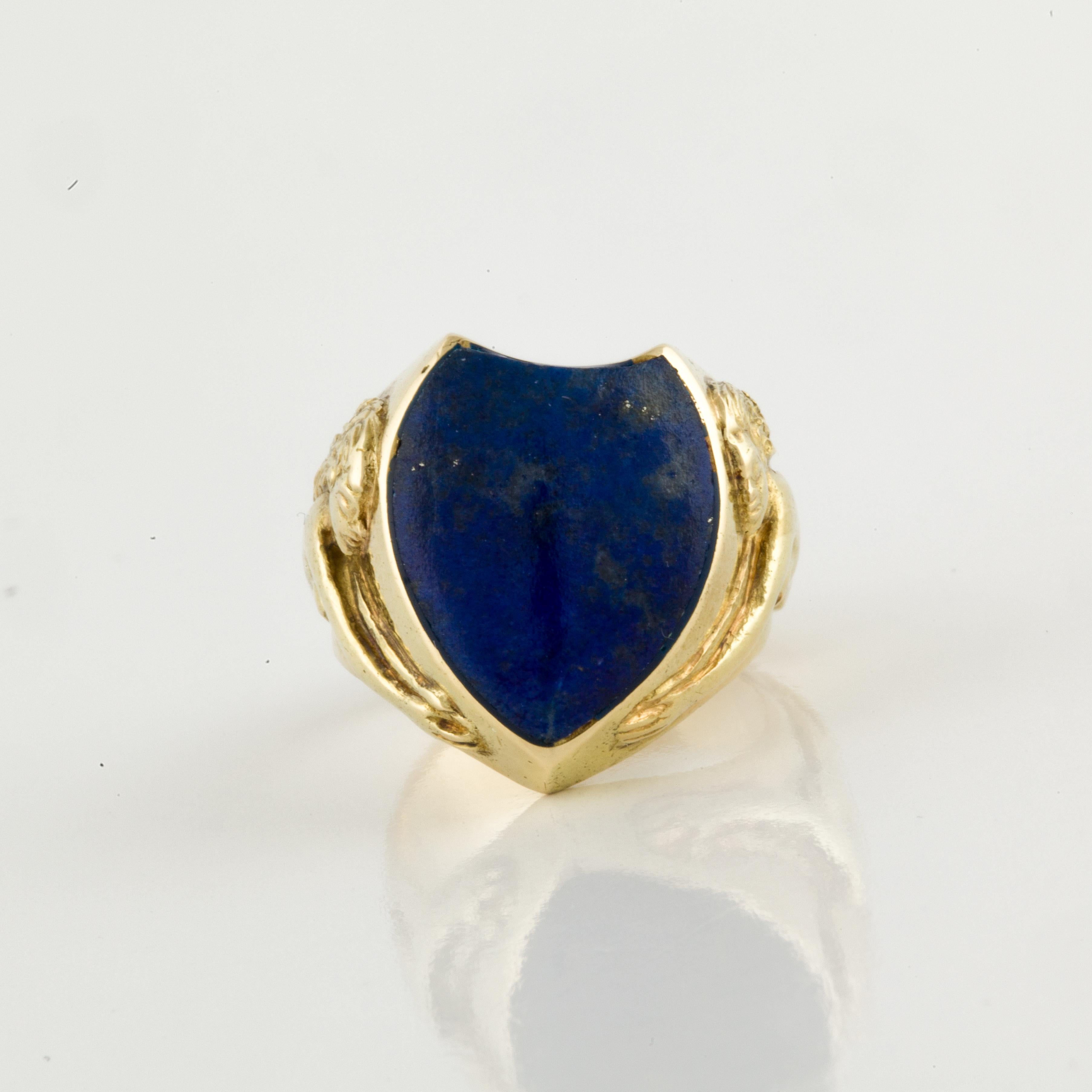 18K yellow gold ring with shield shaped lapis.  On each side of the shank is a female nude with outstretched arms. Ring is currently a size 6.  Presentation area is 3/4 inches by 3/4 inches.