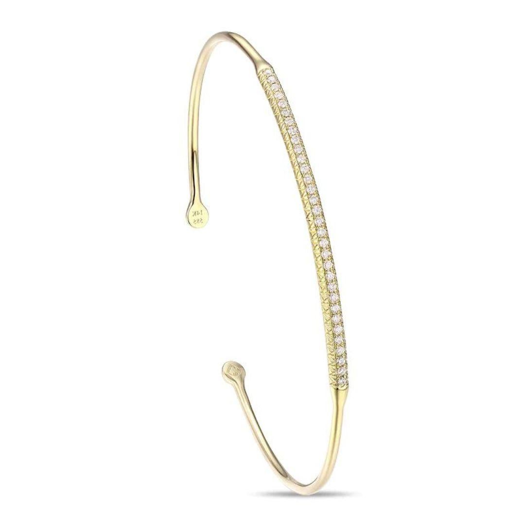 
Trendy 14k yellow gold bangle with pave set round brilliant diamonds. Wear it stacked with other bangles or on its own. Bangle contains thirty two diamonds H-I color, SI clarity, total carat weight 0.22 ctw. One size fits most. Great gift for an