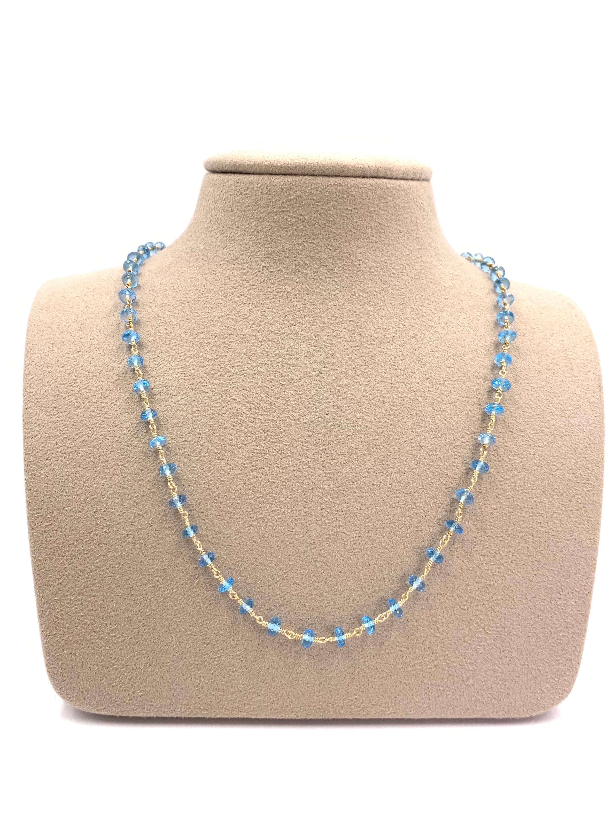 A wearable necklace with a refreshing pop of color. 55 Faceted bead-cut sky blue topaz gemstones are stationed on a 14 karat yellow gold 'dog-bone' style chain. Necklace is fixed with a lobster clasp. Width of each topaz measures approximately 4mm.