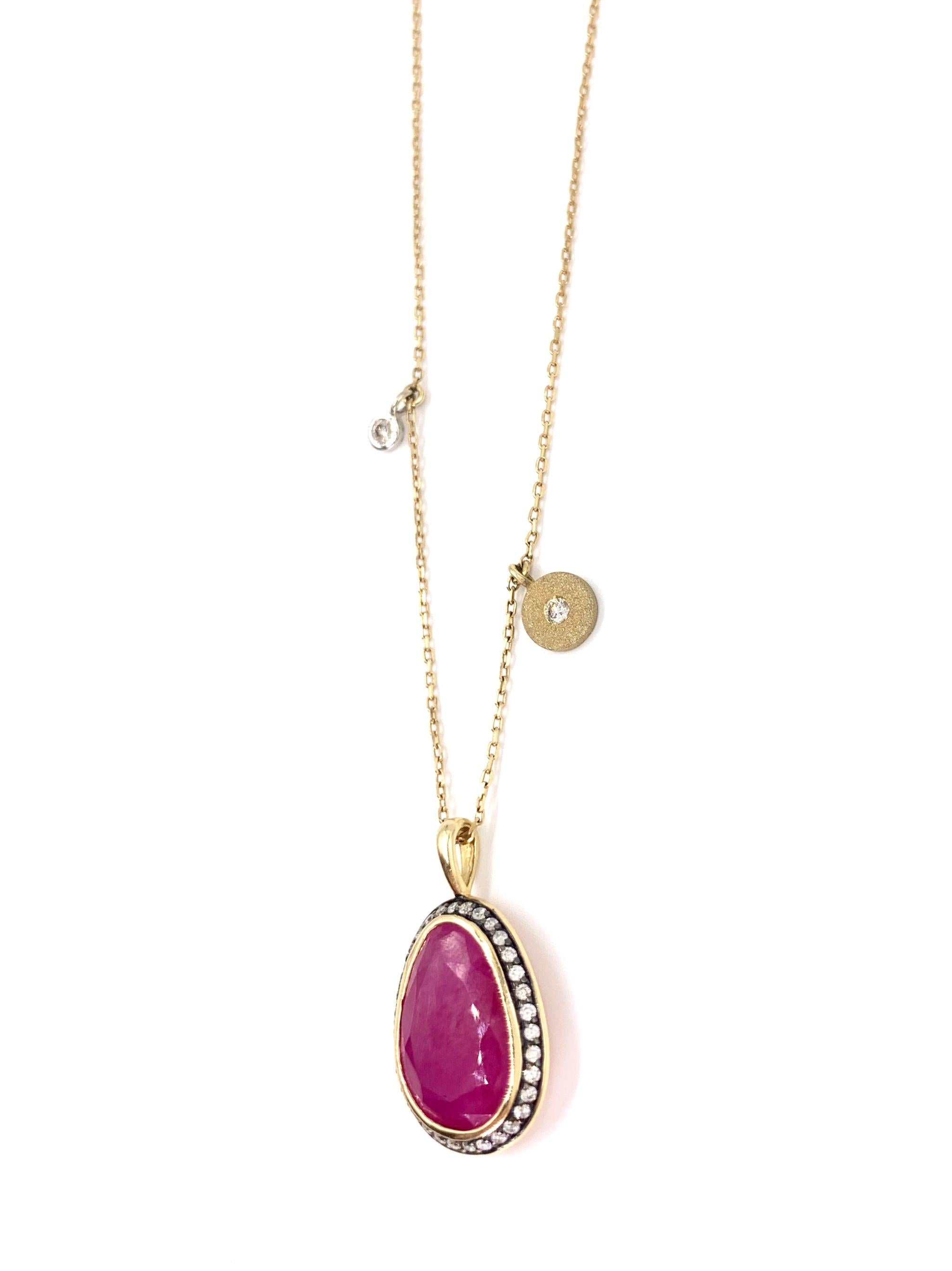 Fashionable and wearable, this 14 karat yellow gold pendant necklace features an organic shaped sliced vivid magenta hue ruby surrounded by white diamonds with two delicate accent diamonds attached to the oval link chain. White round brilliant