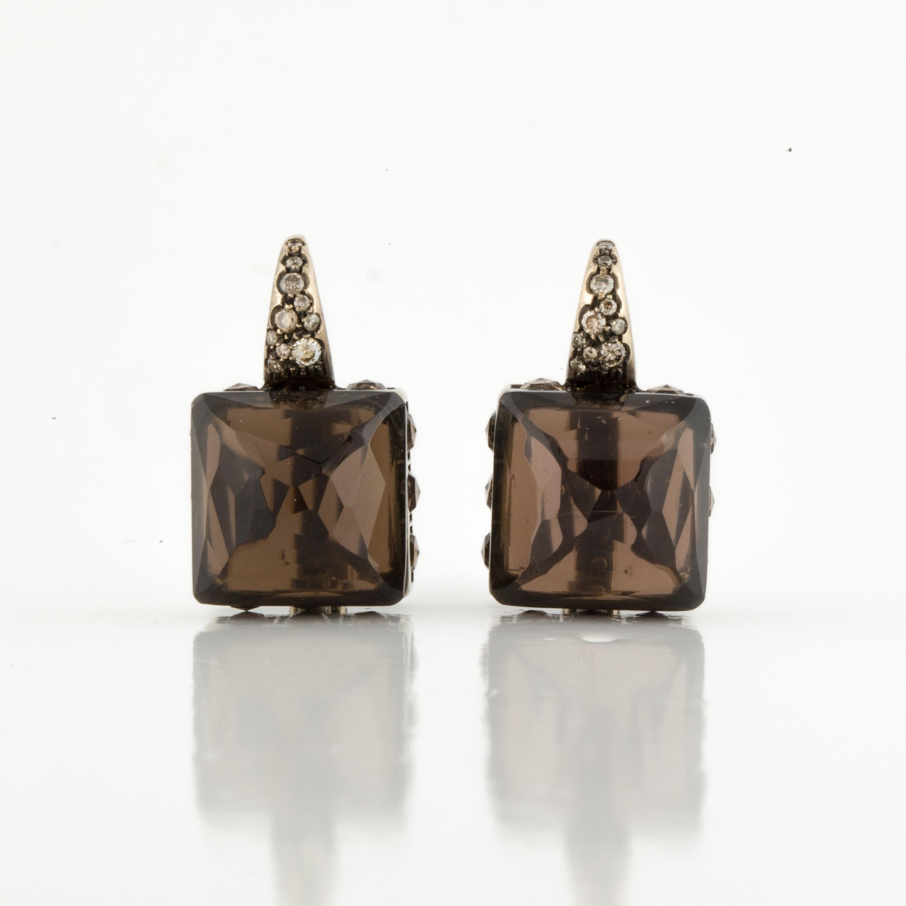 18K yellow brushed gold earrings featuring smokey quartz with diamond accents.  They have two (2) square faceted quartz stones and twelve (12) round faceted quartz stones that total 40 carats.  There are eighteen (18) round diamonds that total 0.25