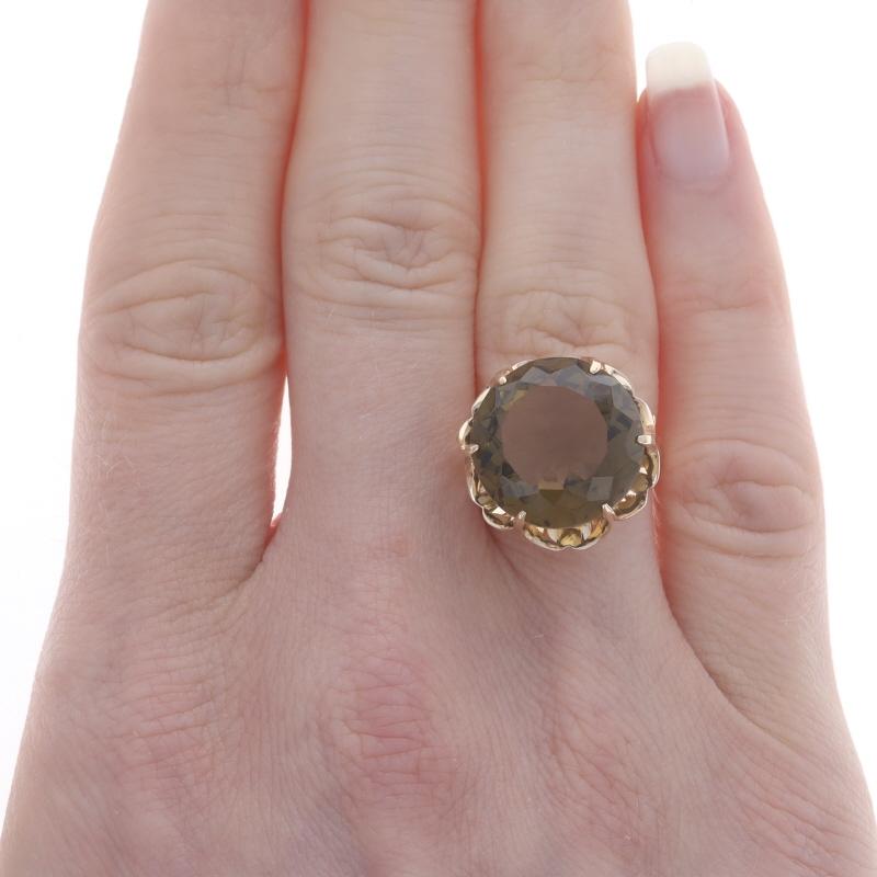 Size: 6 1/2
Sizing Fee: Up 2 sizes for $35 or Down 1 size for $35

Era: Vintage

Metal Content: 14k Yellow Gold

Stone Information

Natural Smoky Quartz
Carat(s): 8.65ct
Cut: Round
Color: Greenish Brown

Total Carats: 8.65ct

Style: Cocktail