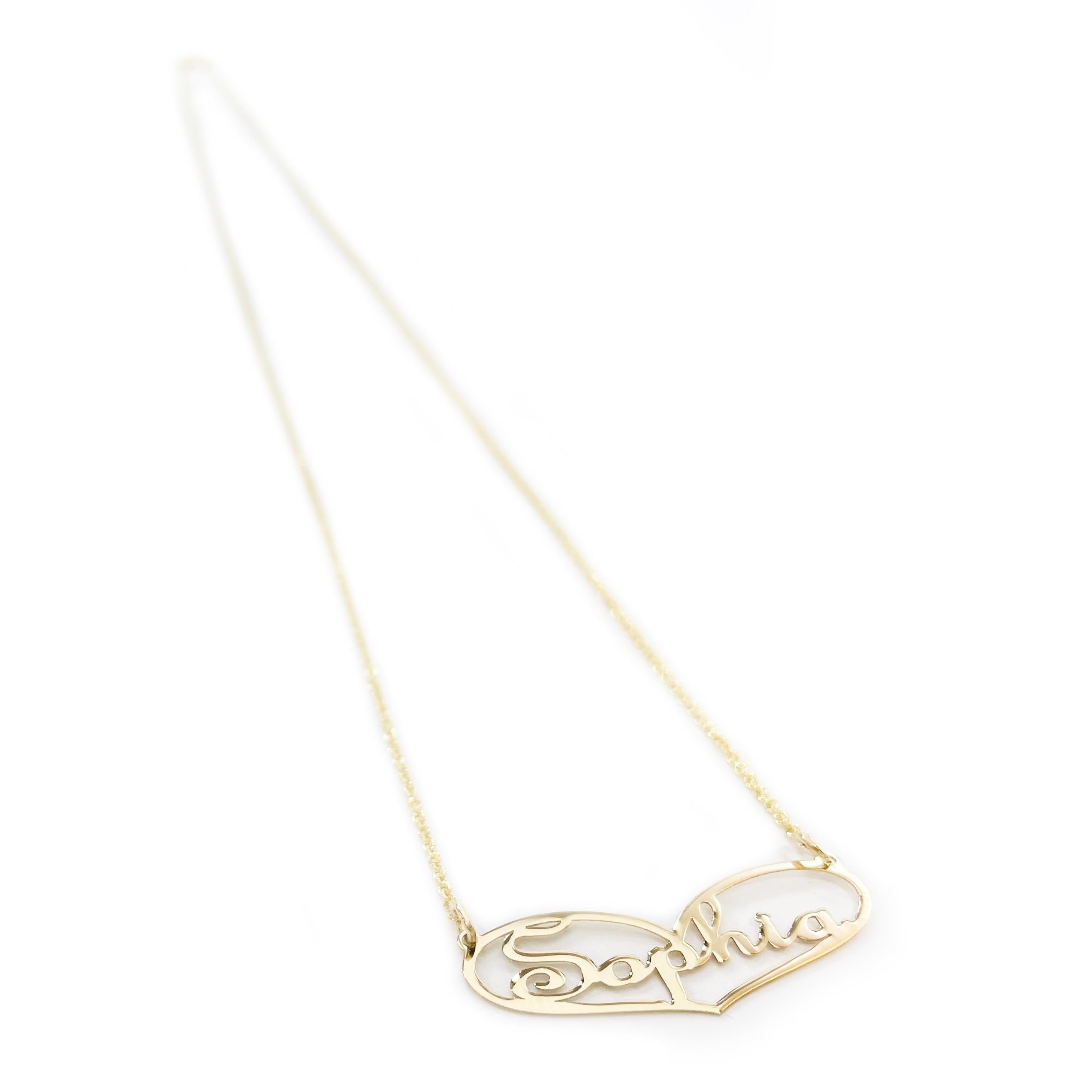 10 Karat Yellow Gold Sophia Name Pendant Necklace. This necklace features an elongated heart shape pendant with the name Sophia inside the heart in a cursive font. The chain is 18