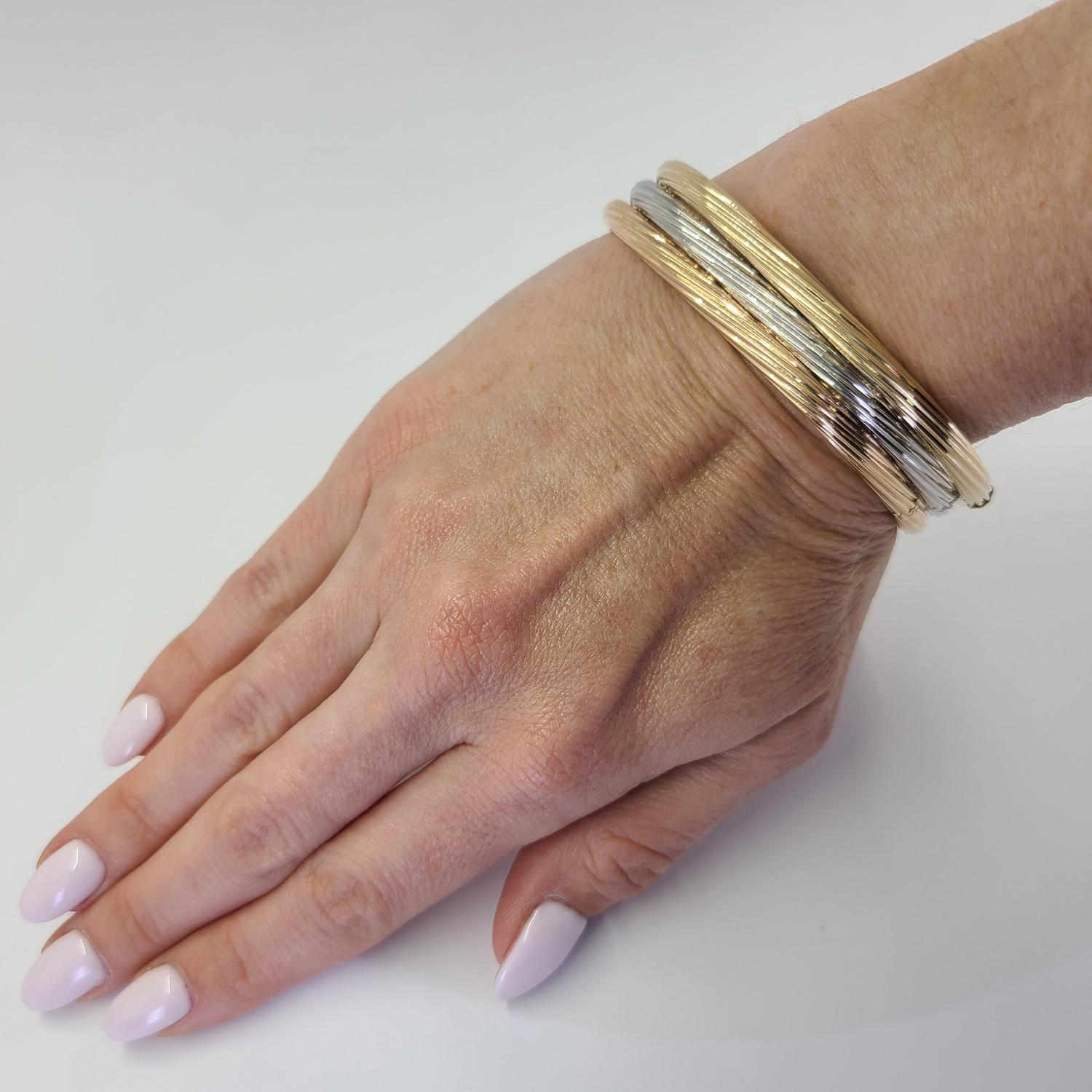 18 Karat Yellow Gold Bangle Featuring A Square Hinged Design with Twist Accent. Hidden Clasp. Finished Weight Is 15.0 Grams.

Matching rose and white gold bangles also available separately.