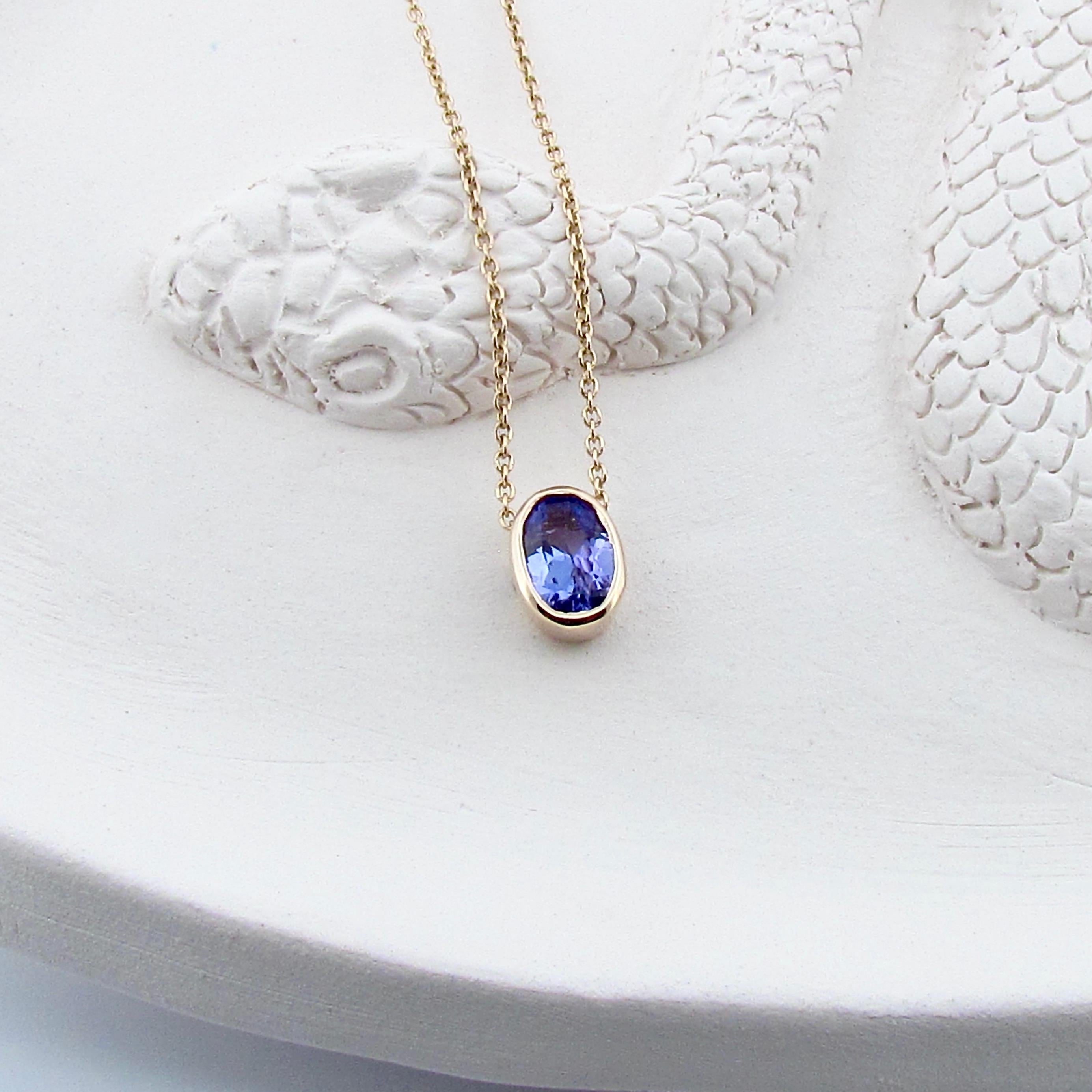This 9ct solid gold small oval pendant is set with a beautifully faceted bright natural 0.90ct Blue Tanzanite, and comes on a 40cm/16inch 9ct yellow gold cable chain, it is superior in quality and has a nice weight to it. The bright blue hue of the