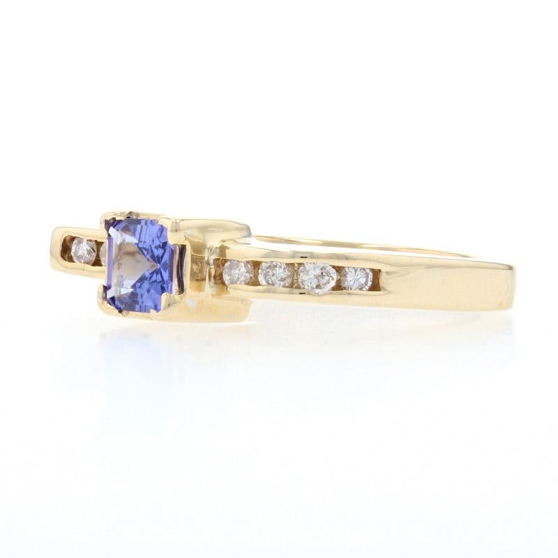 Featuring a sleek, artistic silhouette, this ring hosts a velvety purple tanzanite solitaire accompanied by sparkling white diamonds set in 14k yellow gold.

This ring is a size 6 3/4.

Metal Content: Guaranteed 14k Gold as stamped

Stone