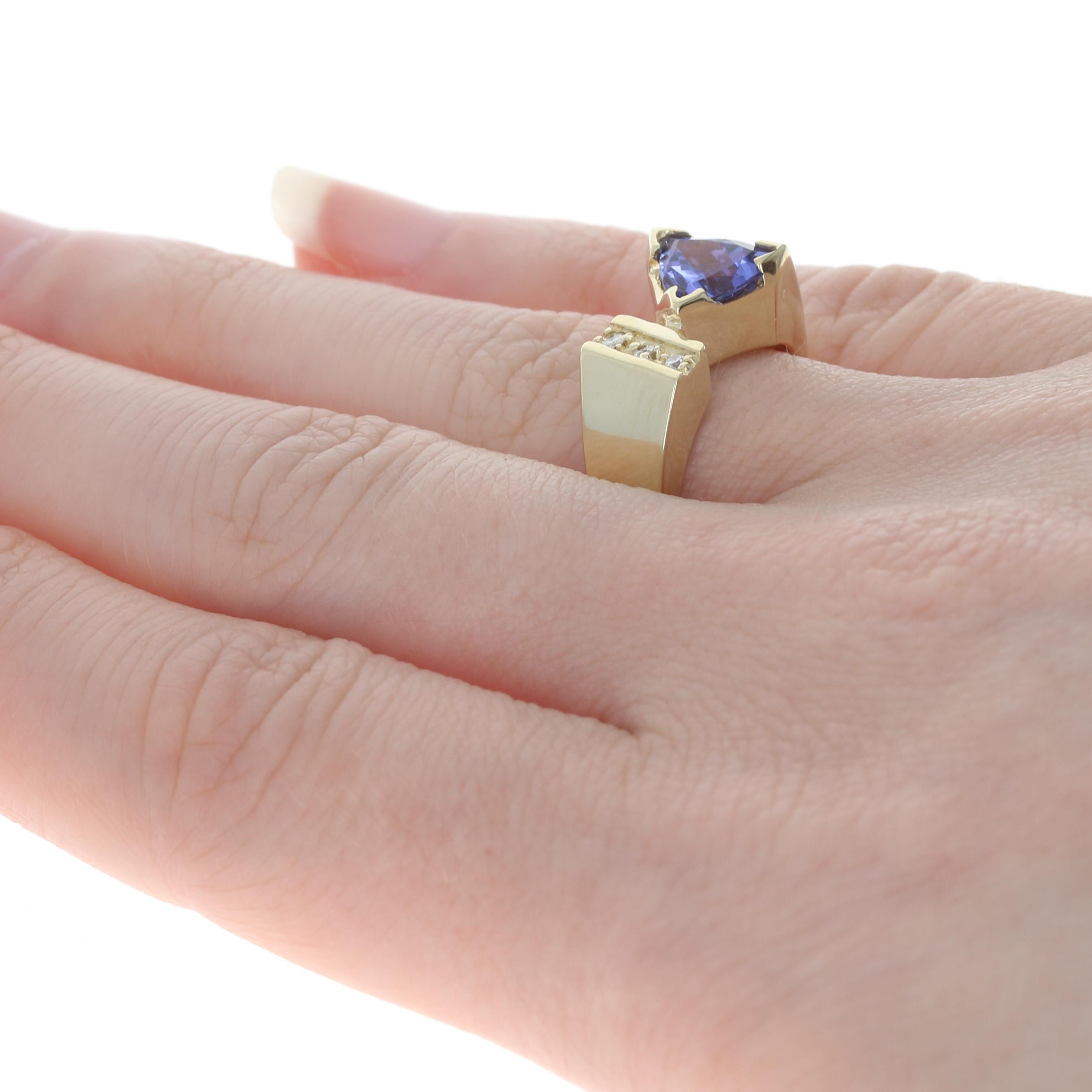 Size: 6 1/2
Sizing Fee: Down or Up 1 size for $25

Metal Content: 14k Yellow Gold

Stone Information: 
Genuine Tanzanite
Treatment: Routinely Enhanced
Carat(s): 1.80ct
Cut: Trillion
Color: Purple 

Natural Diamonds
Carat(s): .09ctw
Cut: Round
