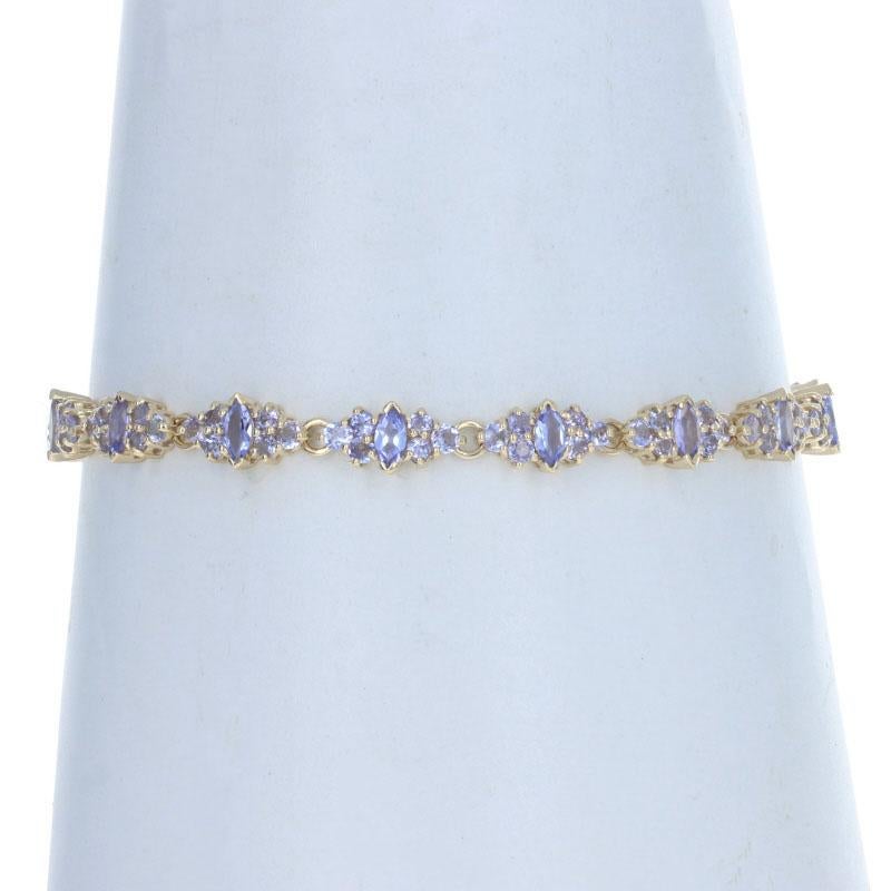 Metal Content: 14k Yellow Gold

Stone Information
Genuine Tanzanites
Treatment: Routinely Enhanced
Total Carats: 6.72ctw
Cut: Marquise & Round
Color: Purple

Style: Link 
Fastening Type: Tab Box Clasp with Two Side Safety