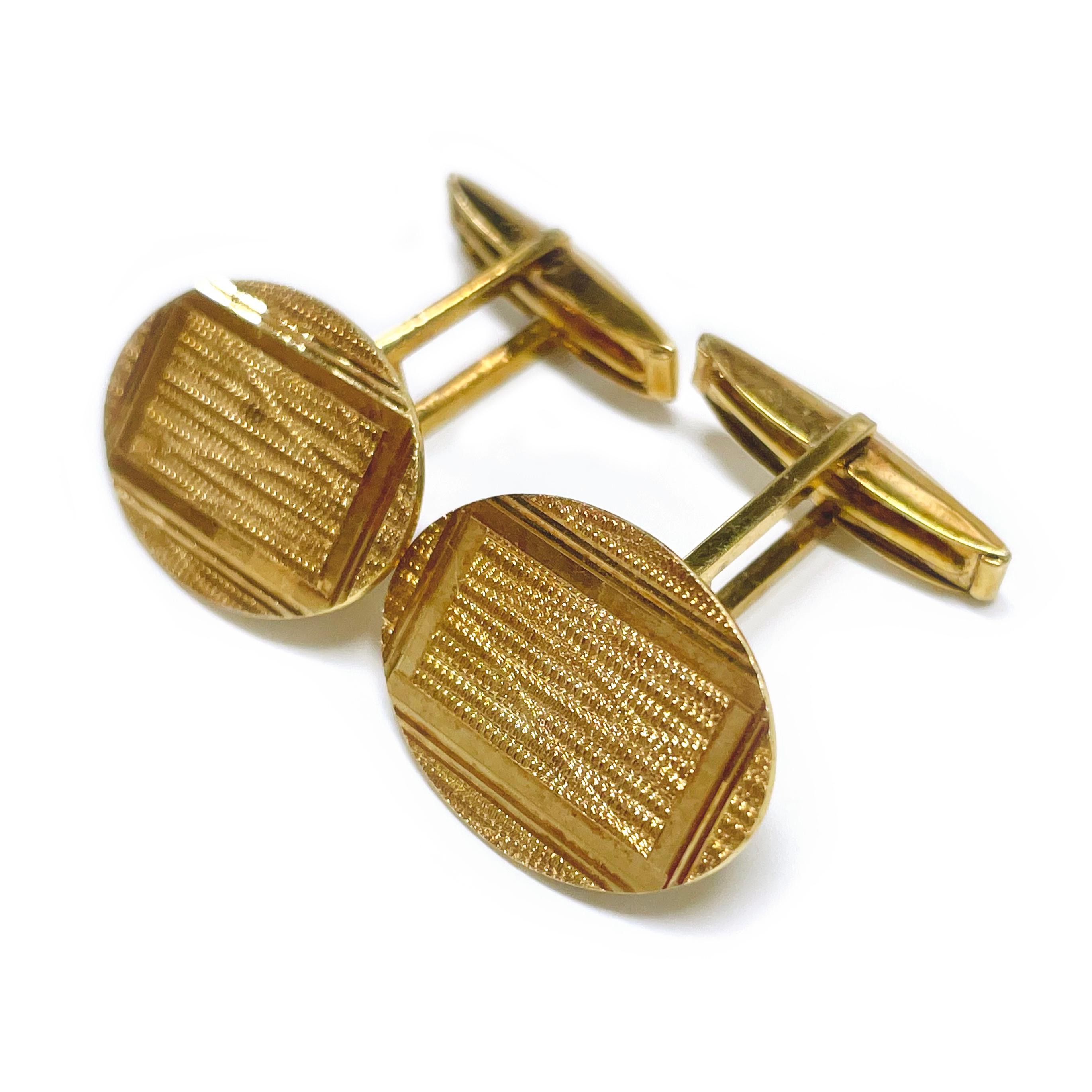 Yellow Gold Textured Cufflinks. The oval cufflinks have textured fronts with a smooth shiny rectangle. The cufflinks have a dual post and whale tail backings. The cufflink fronts measure approximately 20.5mm by 14.6mm. The cufflink front and post
