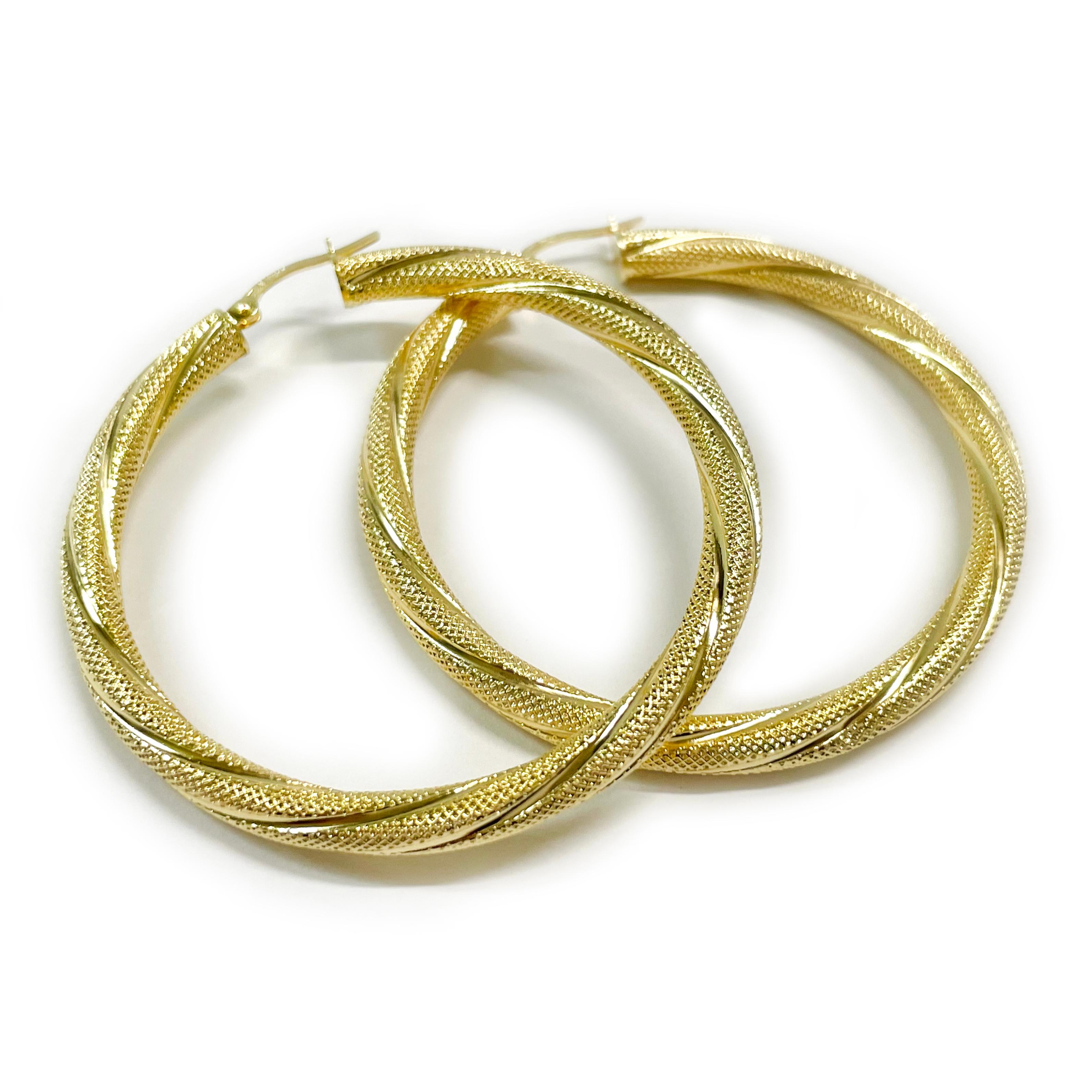 14 Karat Yellow Gold Textured Hoop Earrings. These classic lightweight hoops have a textured swirl pattern for added shimmer. The earrings have a joint and catch closure. Stamped on the joint of each earring is 14K ITALY. Each earrings measures