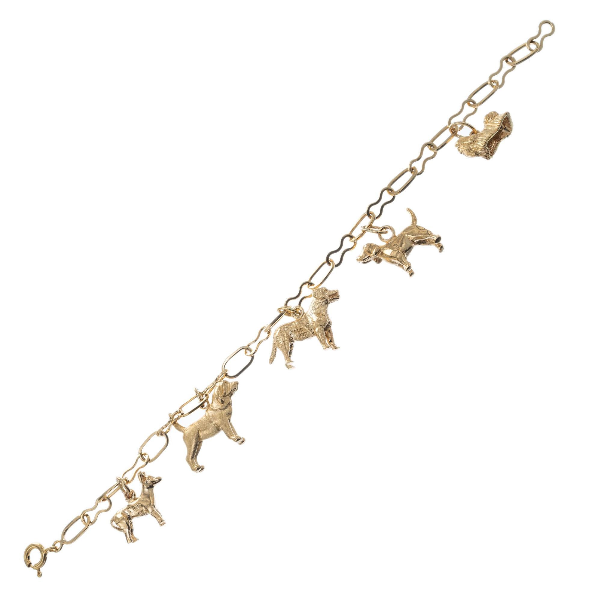 Three-dimensional five dog charm bracelet with a Maltese, Lab, Hound and two other dog charms on a 14k gold link bracelet. 7 inches length. 

14k yellow gold 
Stamped: 14k
18.8 grams
Total length: 7 Inches
Width: 4.6 grams
Thickness/depth: 3.9mm
