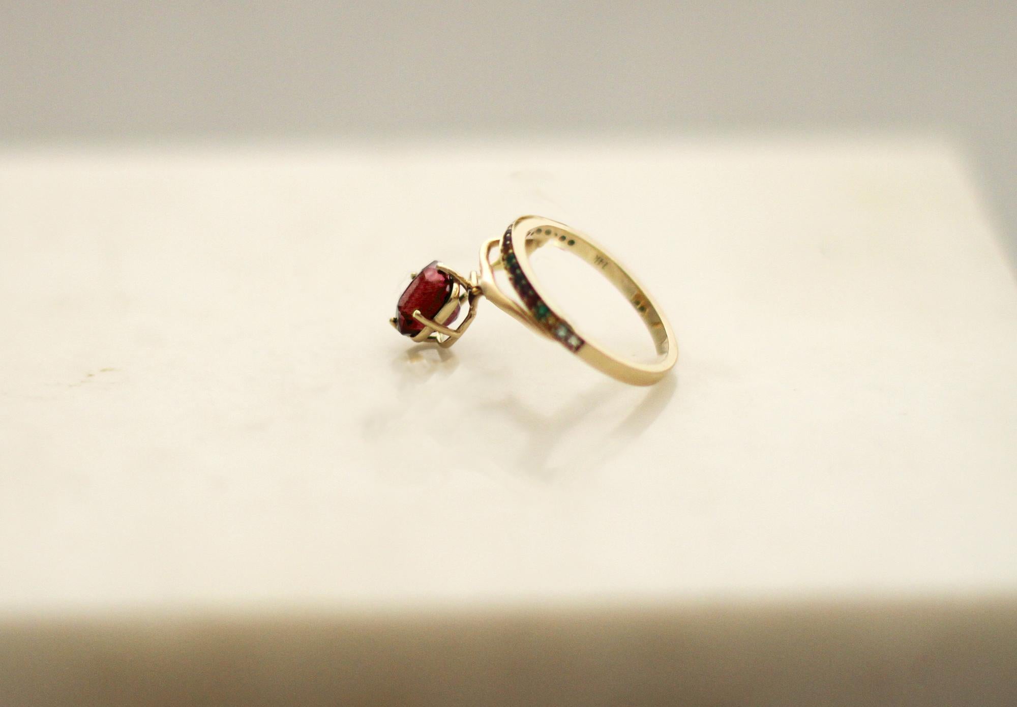 Una forma inusual hace de este anillo contemporáneo tibetano de oro amarillo de 18 quilates un objeto de arte. Lleva incrustados: zafiros de colores, diamantes, esmeraldas y rubí rojo vivo en cojín. La talla se hace a medida. Se inspira en la
