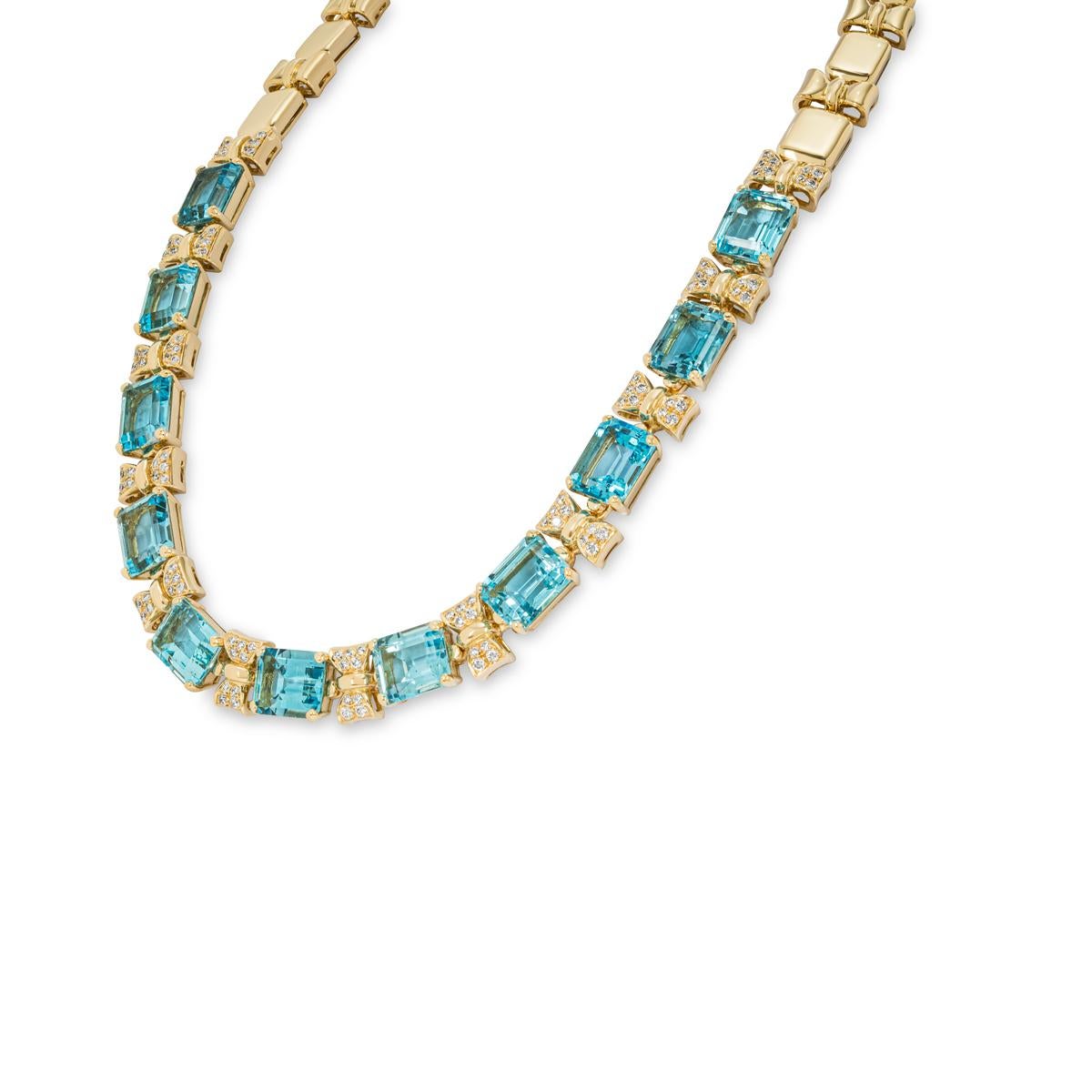 A classy 18k yellow gold topaz and diamond collar necklace. The front of the necklace features topaz alternating with diamond set bow motifs, whereas the back of the necklace features a high polish rectangle link alternating with a high polish bow
