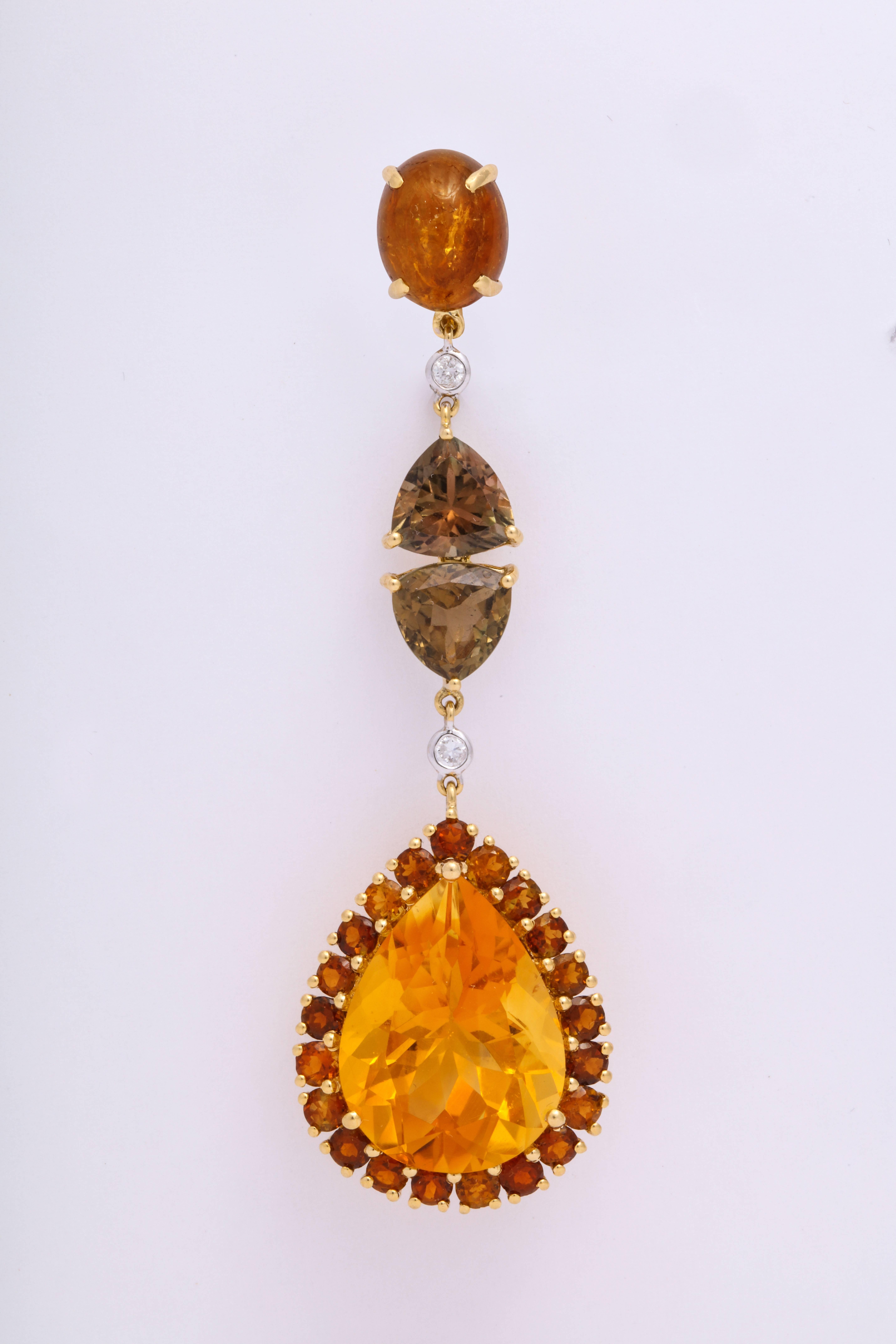Hippie chic 18 Karat yellow gold ear pendant earrings mounted with cabochon yellow tourmaline, greenish gold trillion tourmaline, and pear shaped citrine drops with a surround of round multi-color golden tourmaline. Each component is attached to the
