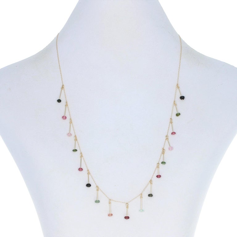 Metal Content: 14k Yellow Gold

Stone Information: 
Genuine Tourmalines
Cut: Rondelle Bead
Colors: Pink & Green

Necklace Style: Drop Station
Chain Style: Curb
Closure Type: Spring Ring Clasp

Attached Drops' Measurements
Tall (from stationary