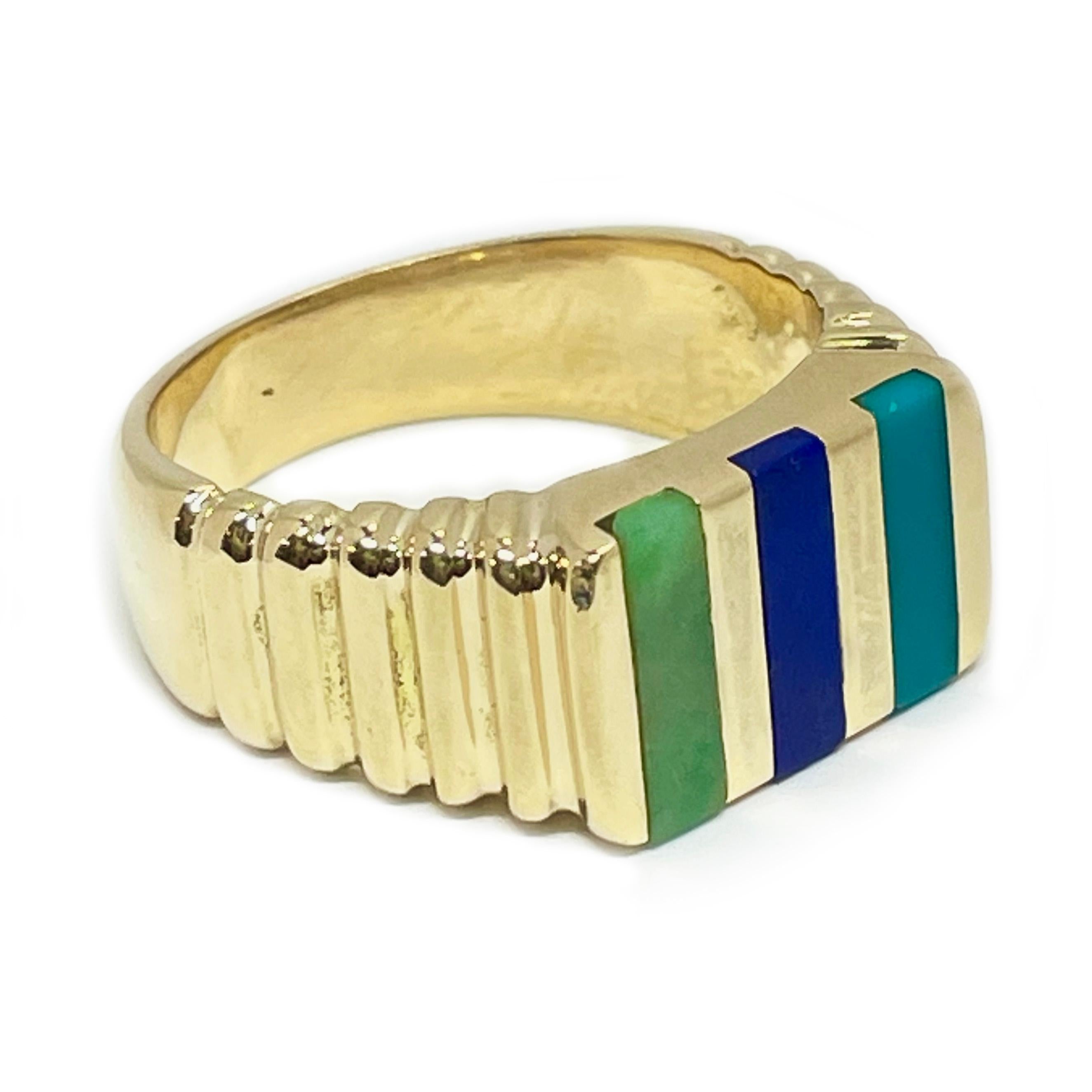 14 Karat Yellow Gold Turquoise, Lapis Lazuli, and green Jade ring. The ring has ridges on about half of the upper shank and a flat top with rectangular inlays of a rich colored turquoise, a vivid lapis lazuli, and a medium green jade. The smooth