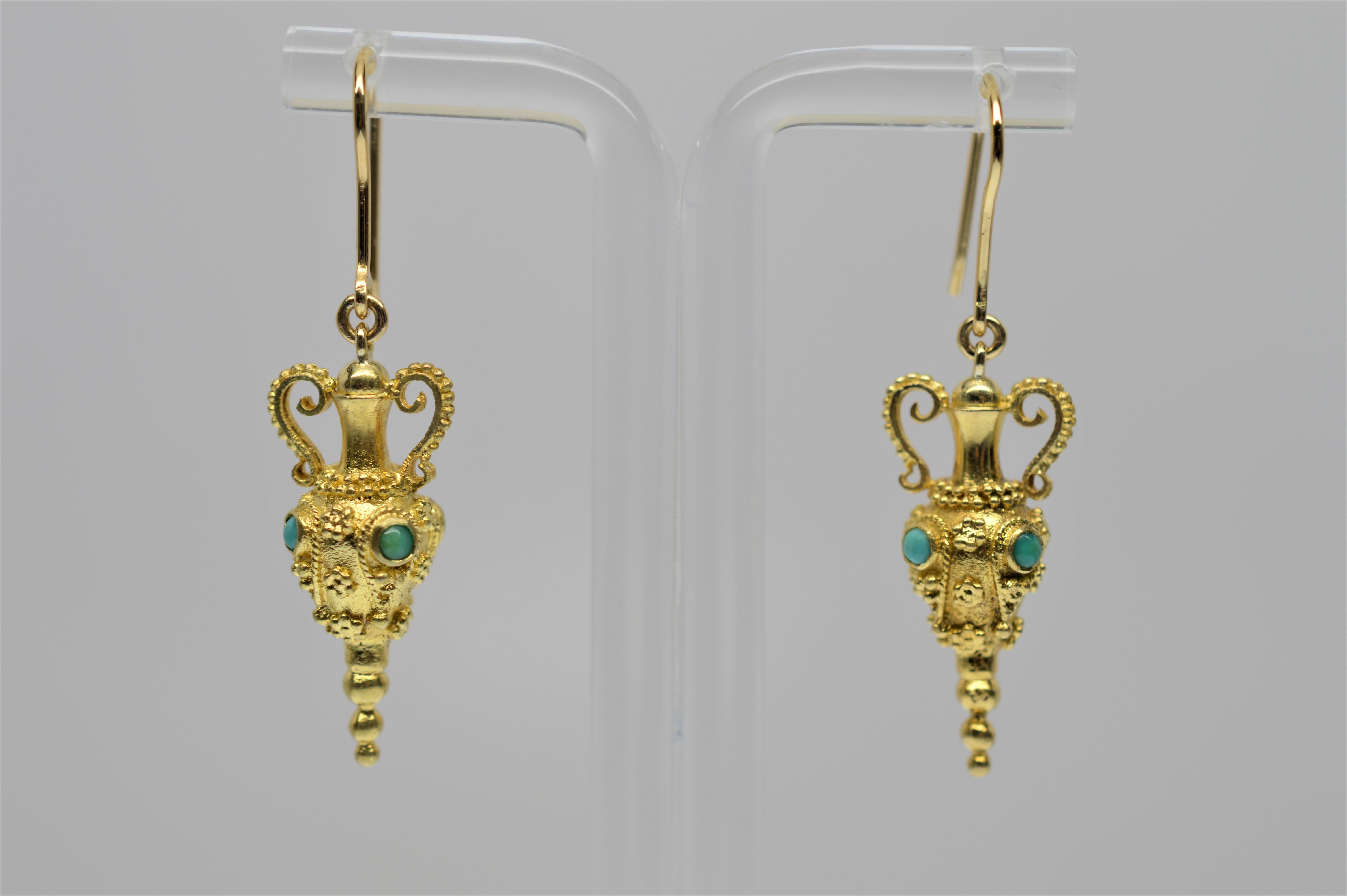 Exotic 18 Karat Yellow Gold Urn Drop Earrings with Turquoise Accents.  These ornate gold drop earrings artistically display in detail, miniature urn-shaped charms accented with dark and light turquoise stones and measures 1-1/4 inch. Hanging from