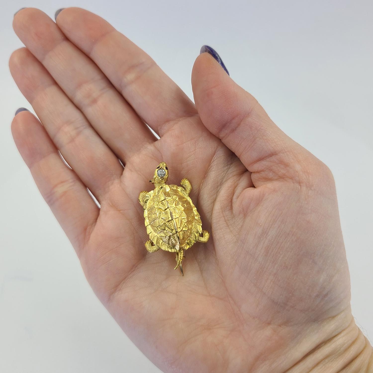 14 Karat Gelbgold Antike Schildkröte Pin mit Satin Finish Textur, 0,03 Karat Old European Cut Diamant und 0,01 Karat Rubin Augen. Das fertige Gewicht beträgt 7.0 Gramm.