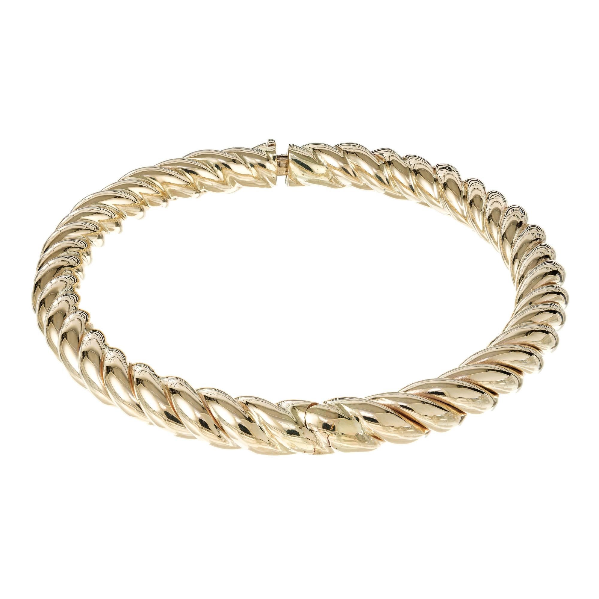 1970's Twisted spiral design Italian yellow gold bangle bracelet. Hinge and clasp are on the right. 

14k yellow gold 
Stamped: 14k
19.4 grams
Width: 6.8mm
Thickness/ Depth: 6.8mm
Inside dimensions: 6.8mm
Inside dimensions: 2.5 inches x 2.25 Inches