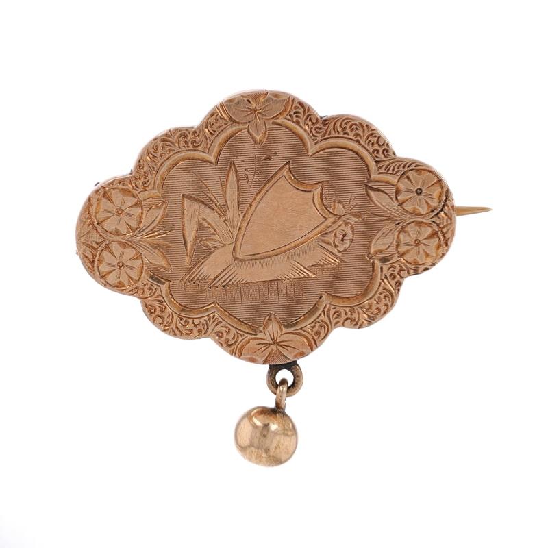 Era: Victorian
Date: 1860s - 1880s

Metal Content: 14k Yellow Gold

Style: Dangle Brooch
Fastening Type: Hinged Pin and C-Clasp
Theme: Shield, Floral
Features: Smoothly Finished with Etched Detailing

Measurements
Tall: 1 3/32