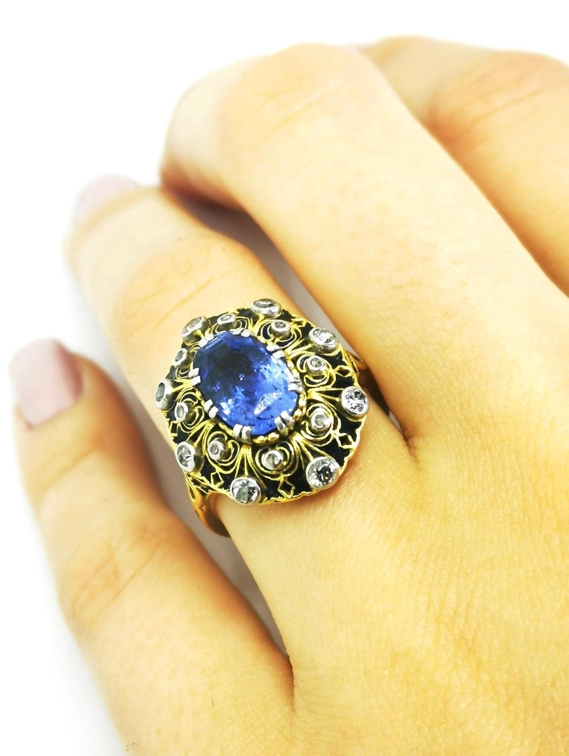 Vintage blue Sapphire and Diamonds ring

Vintage ring in 19.2K yellow gold and silver structure, mounted with natural blue Sapphire with 3.42ct in the center, surrounded by yellow gold and enemal decorations with 16 diamonds.
Top of ring measures