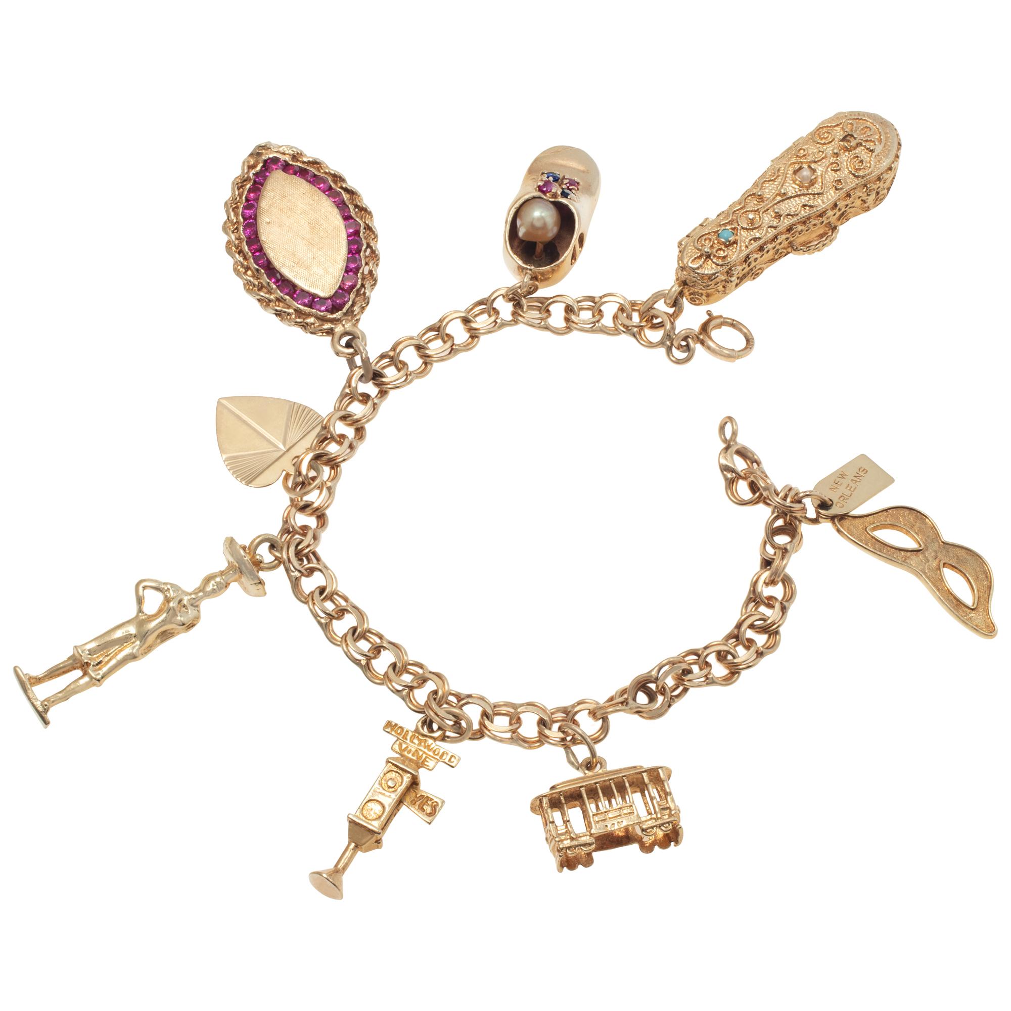 Yellow gold vintage charms bracelet with 8 unique vintage charms