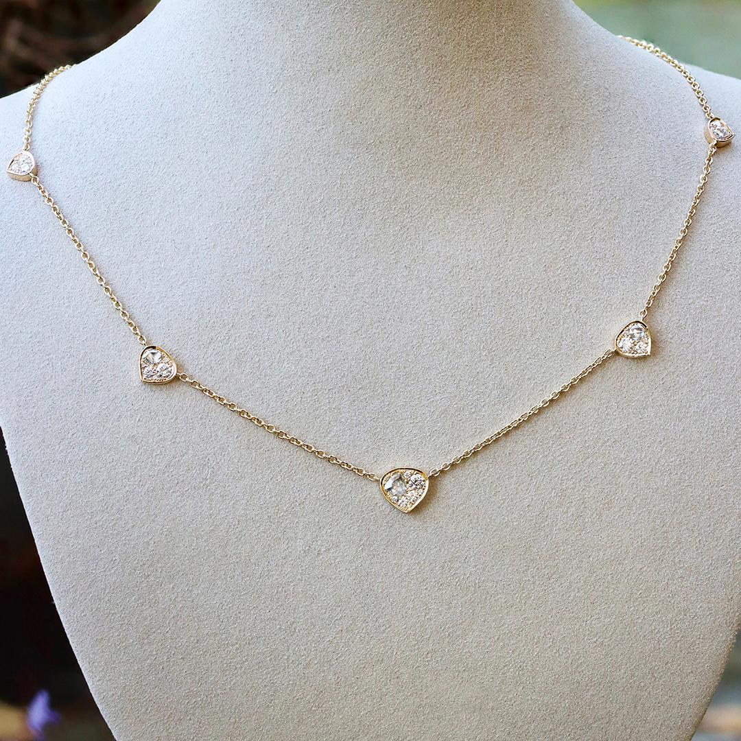 Este extraordinario collar colgante de alta joyería incluye 5 colgantes engastados con diamantes blancos naturales talla rosa de forma fantasía y diamantes blancos talla brillante con una refinada silueta de corazón de trillón suavemente redondeado,