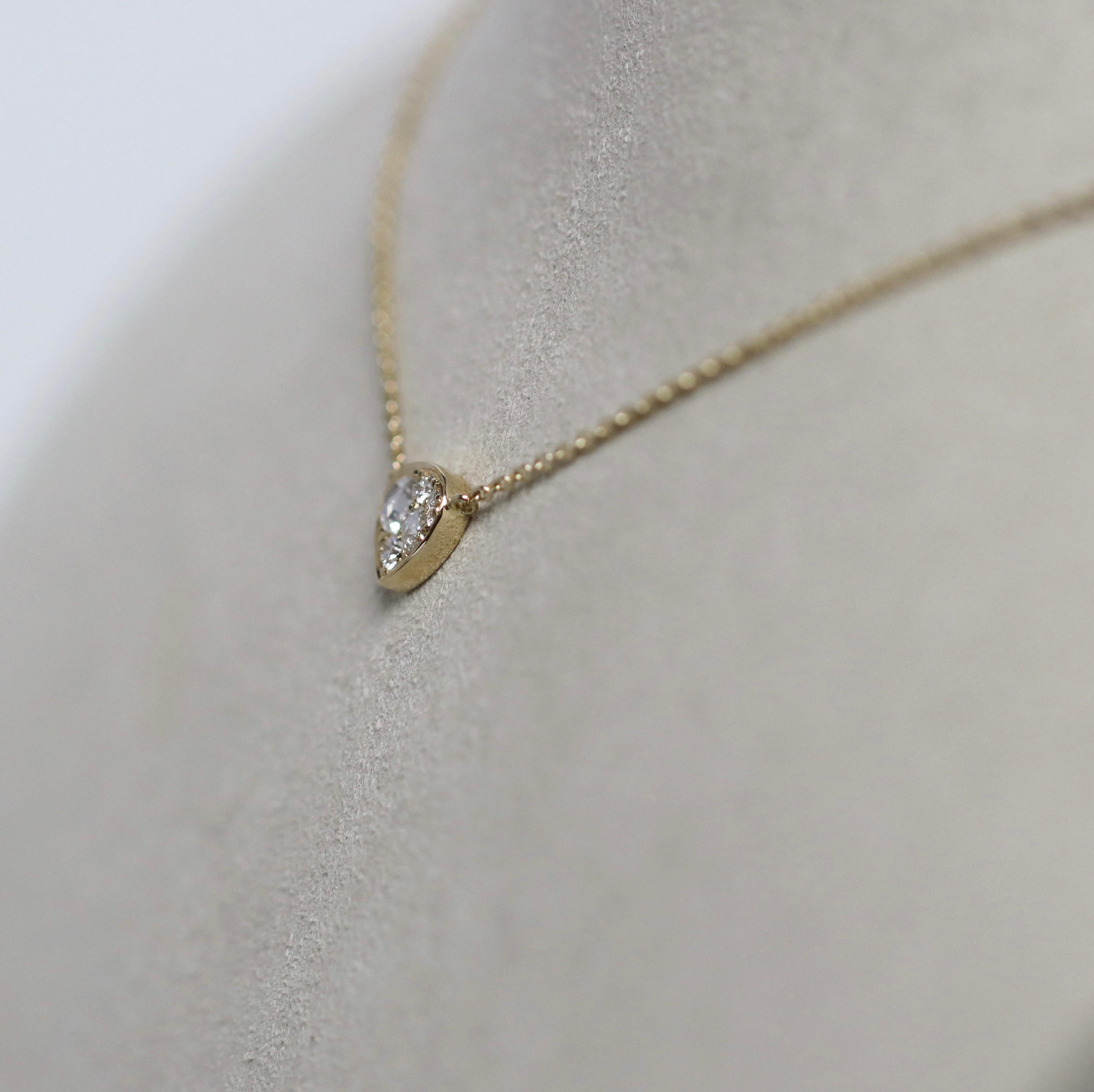 Cet extraordinaire collier-pendentif de joaillerie fine de l'artiste joaillière Joke Quick présente une silhouette raffinée et doucement arrondie en forme de trillion-cœur, un triangle délicat dont les douces courbes font subtilement écho à la forme