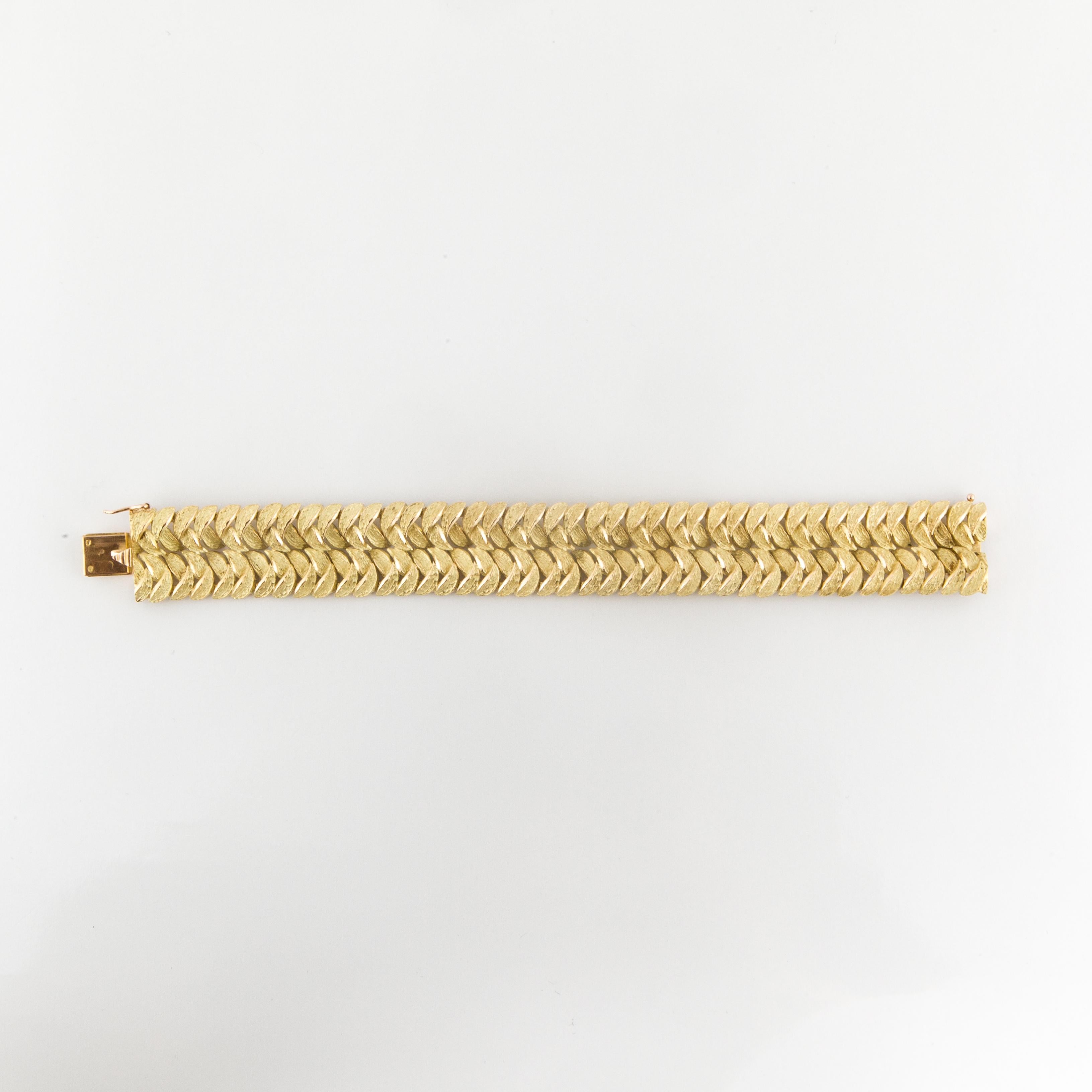 18K textured yellow gold bracelet made in France for Neiman-Marcus.  The bracelet features double rows of a woven leaf design.  Measures 7 1/8 inches long and 3/4 inches wide.  Tongue closure with figure eight safety.