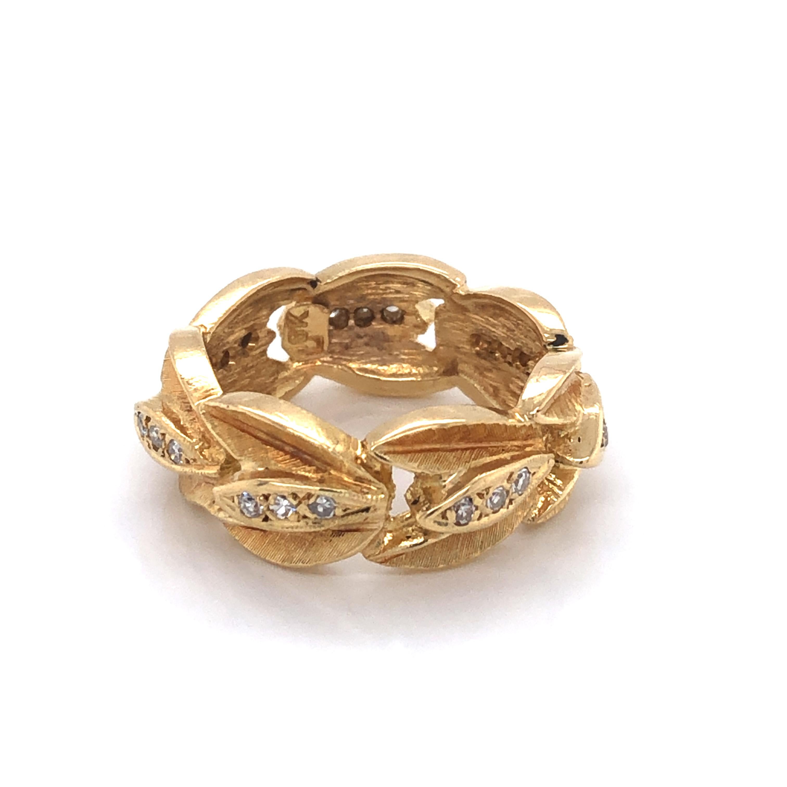 Italian-made in eighteen karat 18K yellow gold are olive leaf inspired branches as symbol of peace and friendship, in a wreath pattern to create this uniquely elegant band style ring. 
The center of each textured gold spray is adorned with petite