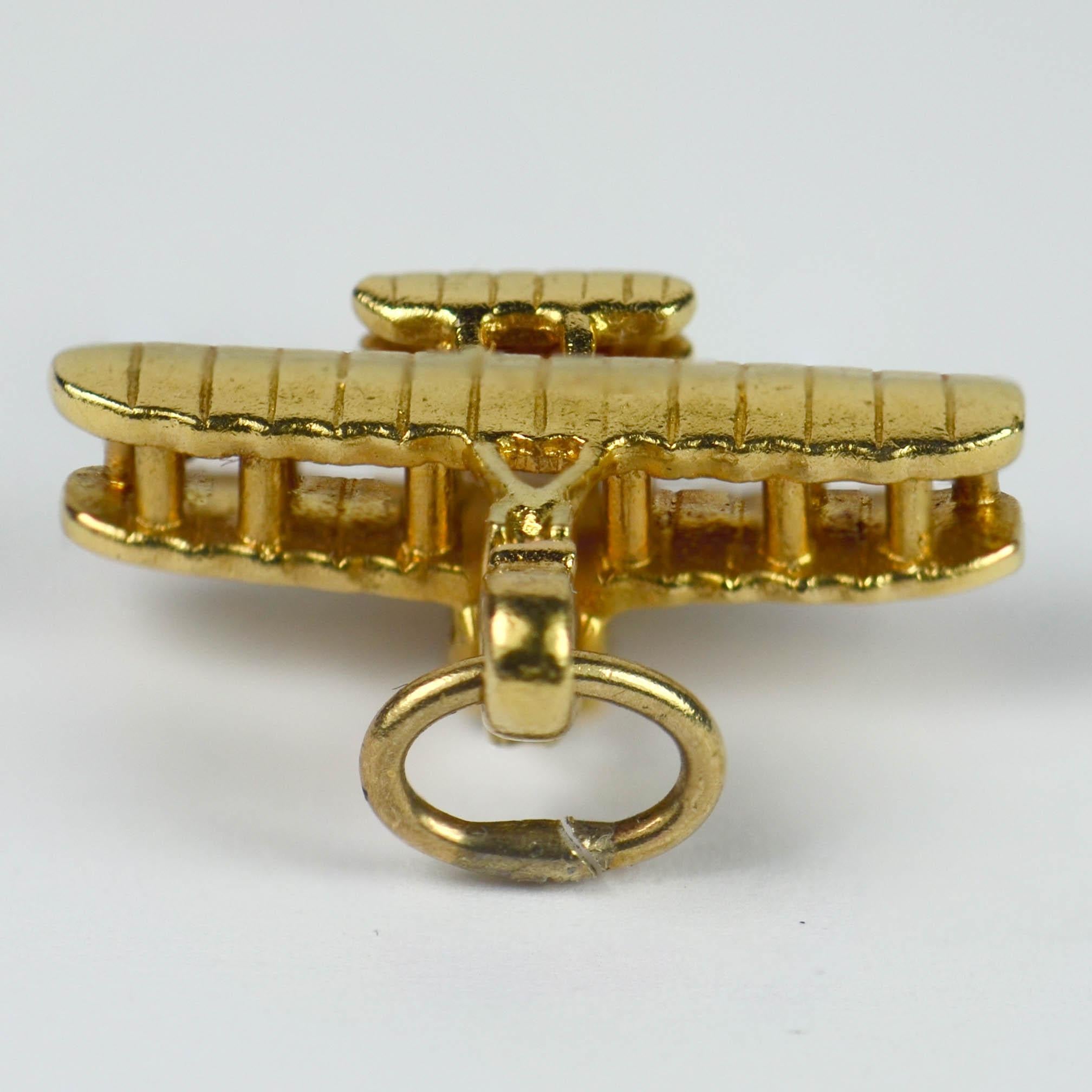 A 14 karat yellow gold charm pendant designed as the 1909 'Model A' Flyer - a biplane designed by the Wright Brothers which was sold to the US Army Signal Corps in July 1909 as the first American military airplane.

Marked 'WRIGHT BROS FLYER' and