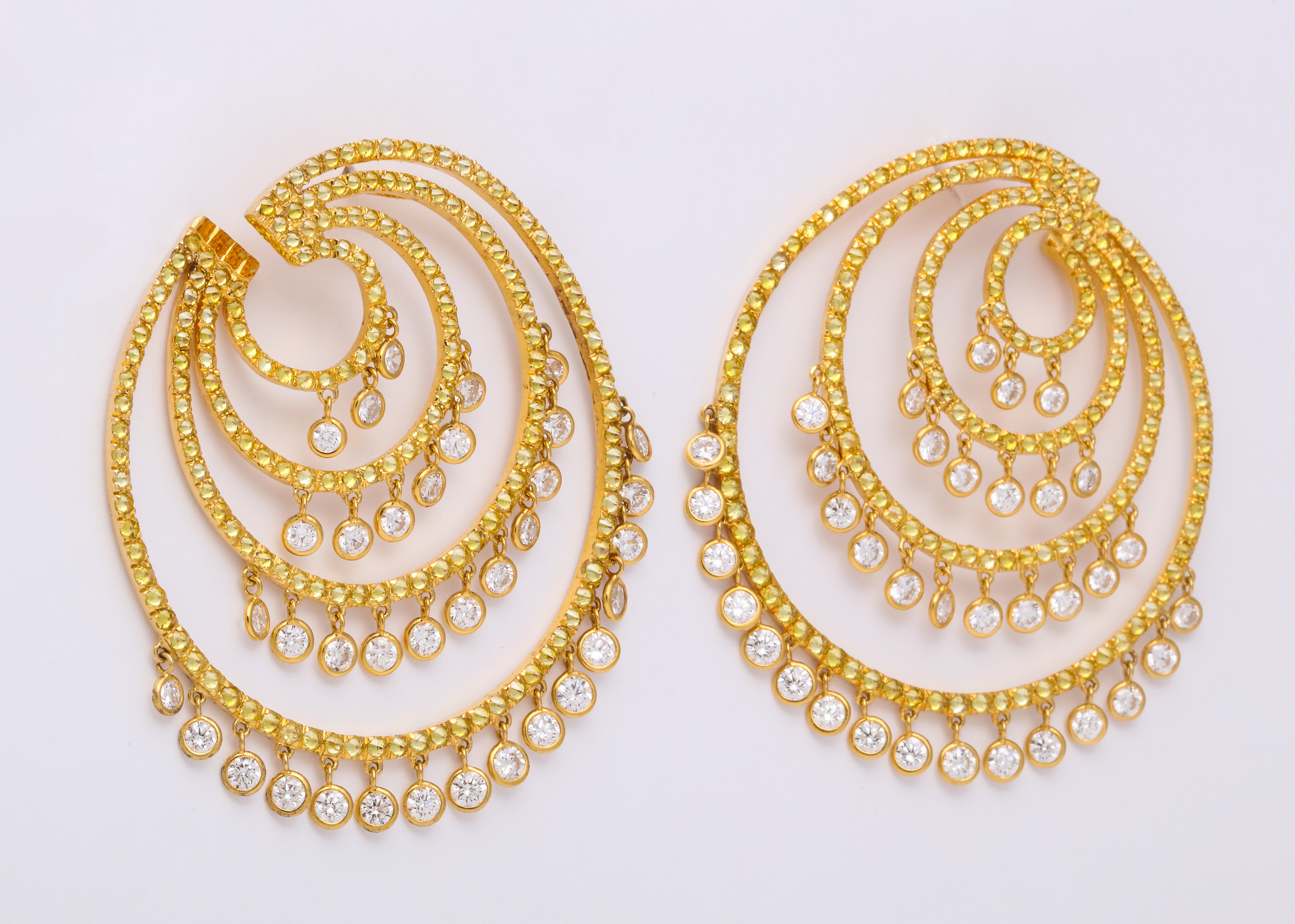 Light and airy 18K yellow gold quadruple C-Scroll earrings decorated with pave'-set inverted round brilliant-cut natural color diamonds: 6.82 carats, suspending 4 tiers of articulating, collet-set round brilliant-cut colorless diamonds: 6.25 carats.