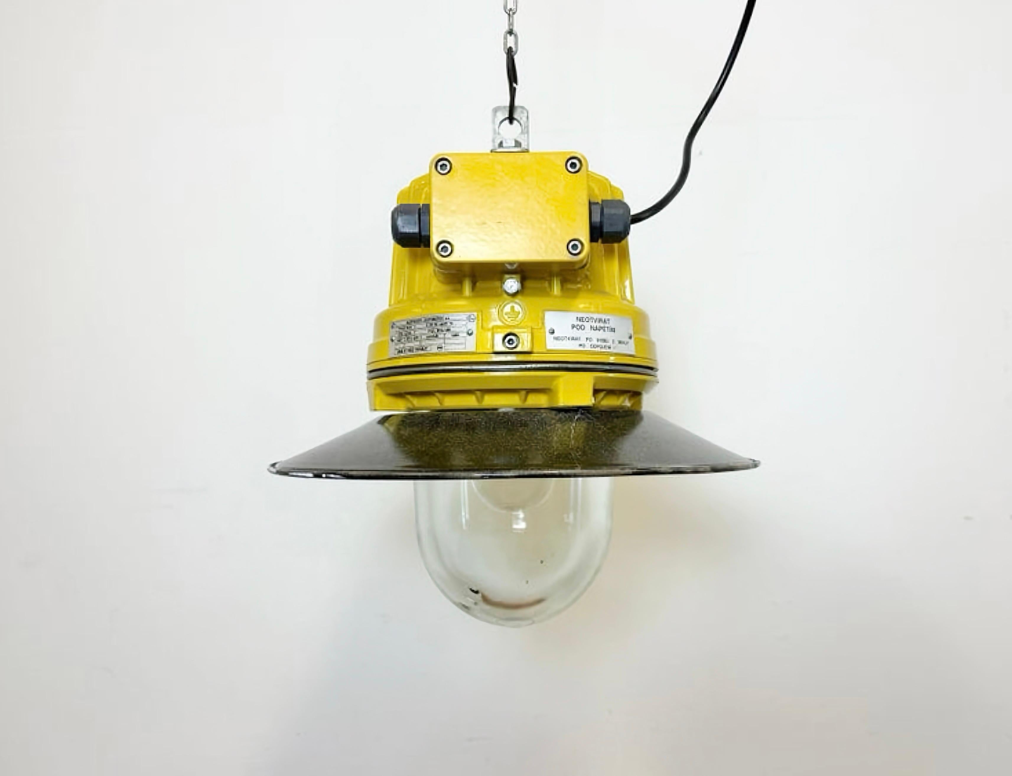 Industrial factory pendant light manufactured by Elektrosvit in Czech Republic during the 1990s. It features a yellow cast aluminium body, an explosion-proof glass and a grey enameled shade with white enameled interior.
The socket requires standard